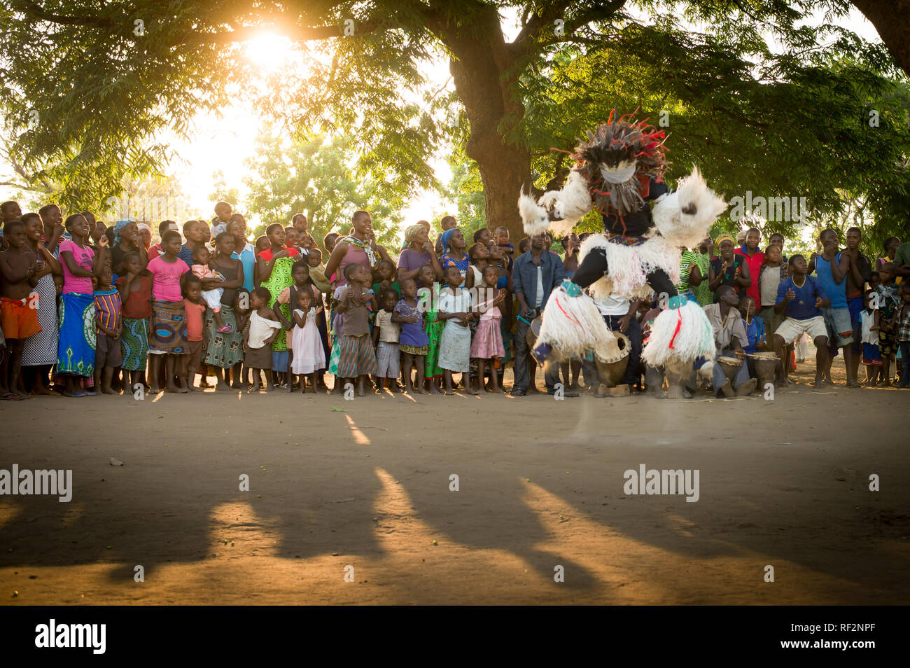 A Gule Wamkulu dancer jumps for a crowd of onlookers near Chikwawa, Malawi; the Gule Wamkulu is a ritual dance performed by the Chewa people. Stock Photo