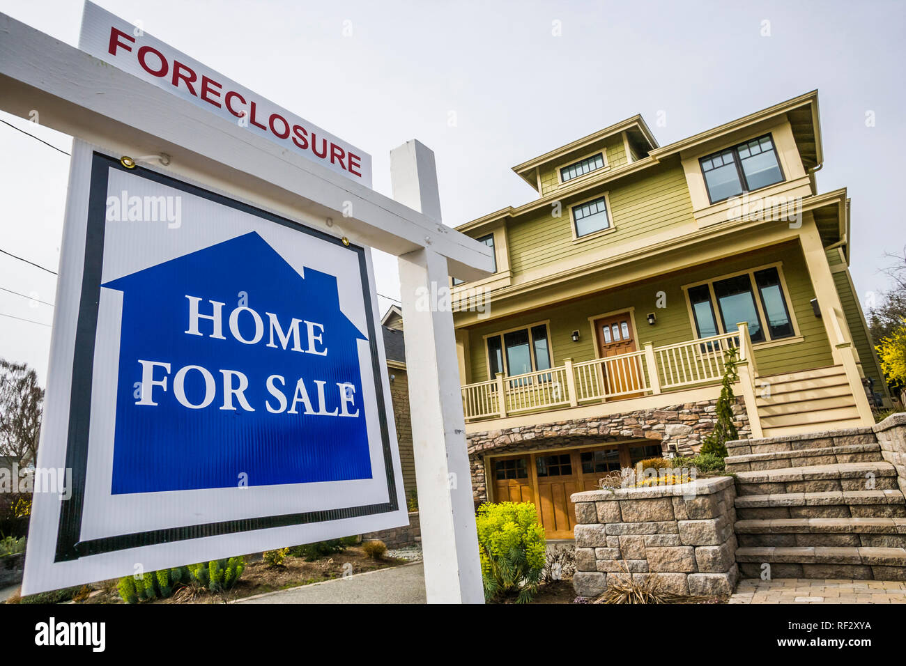 Home with a 'for Sale' sign in front of it. Stock Photo