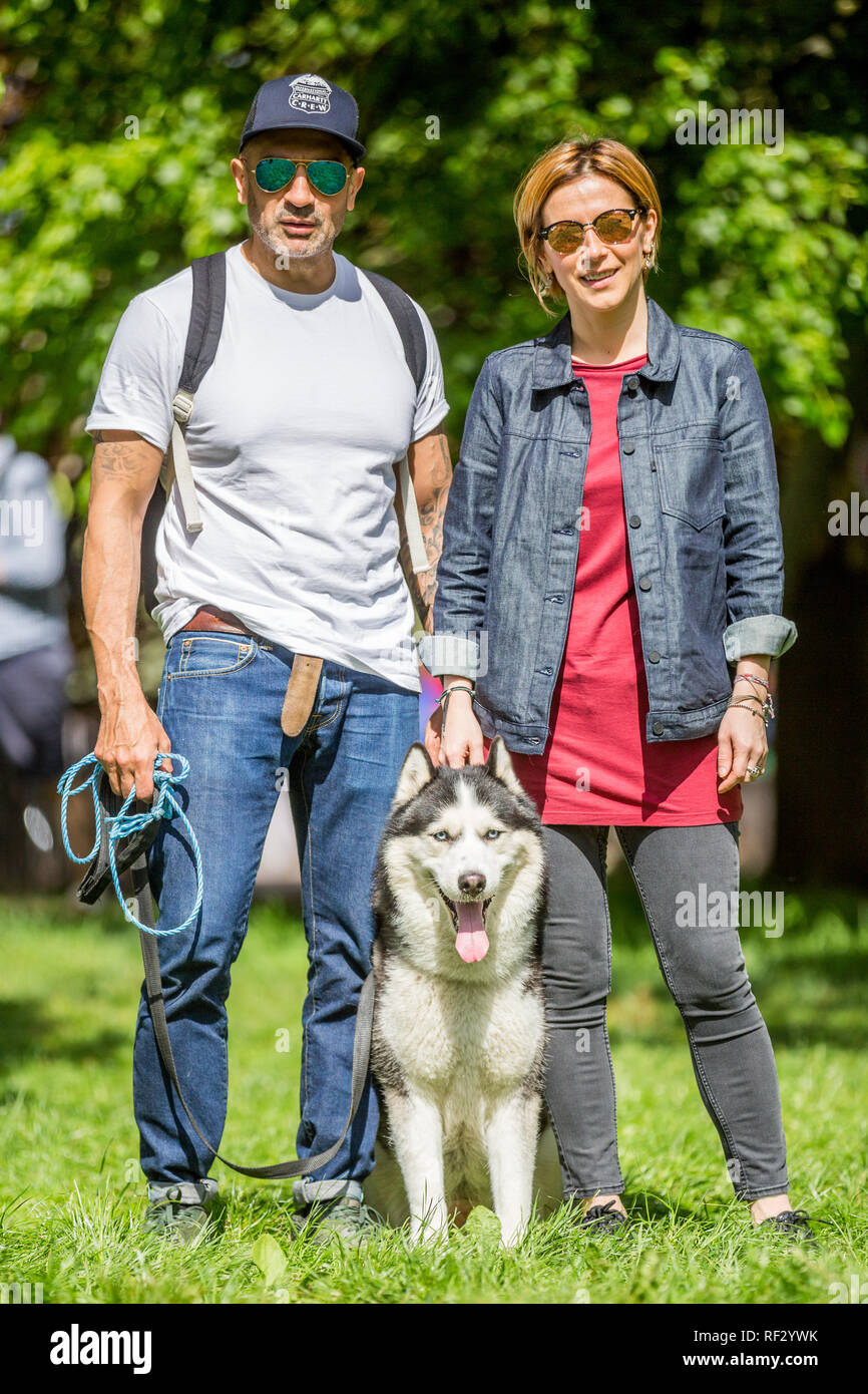 A couple with their dog - a husky in the park at a dog show Stock Photo