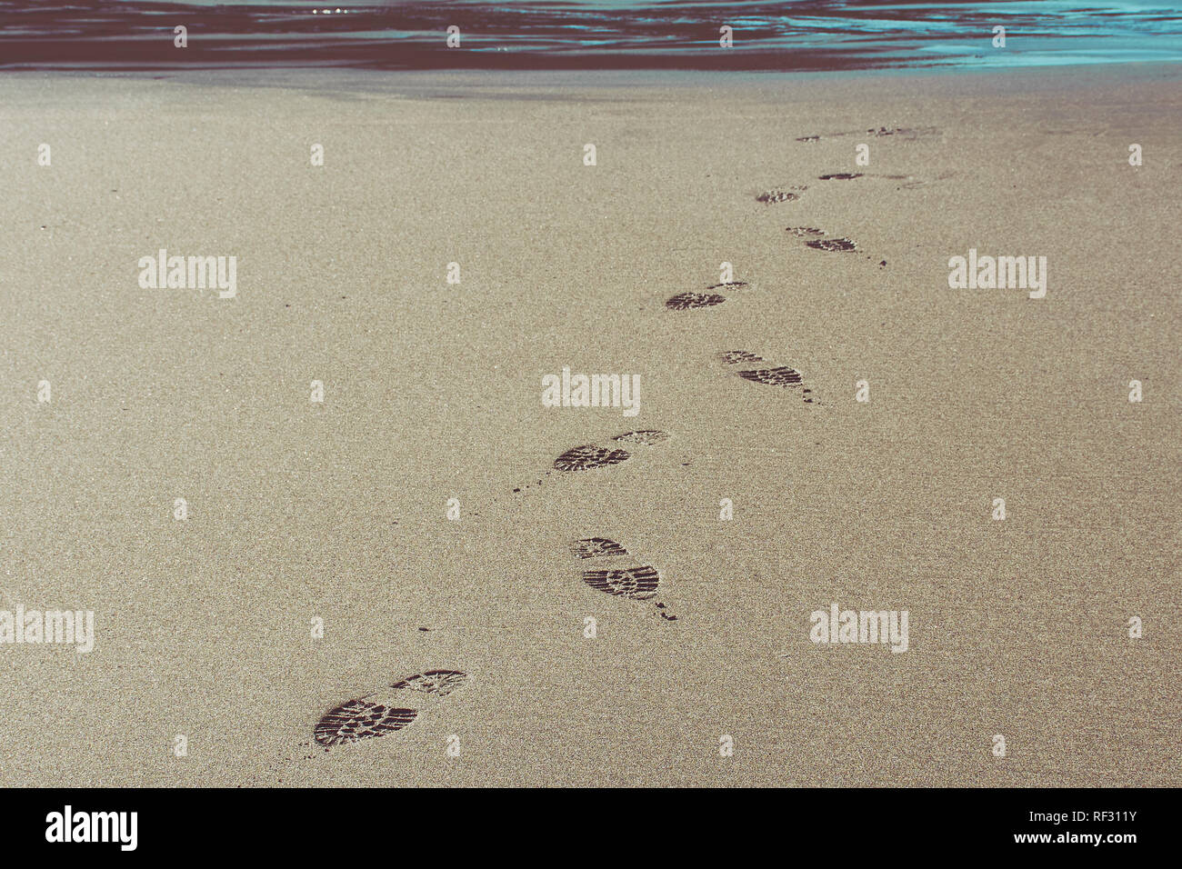 shoe prints in the sand on Trebarwith strand beach Stock Photo