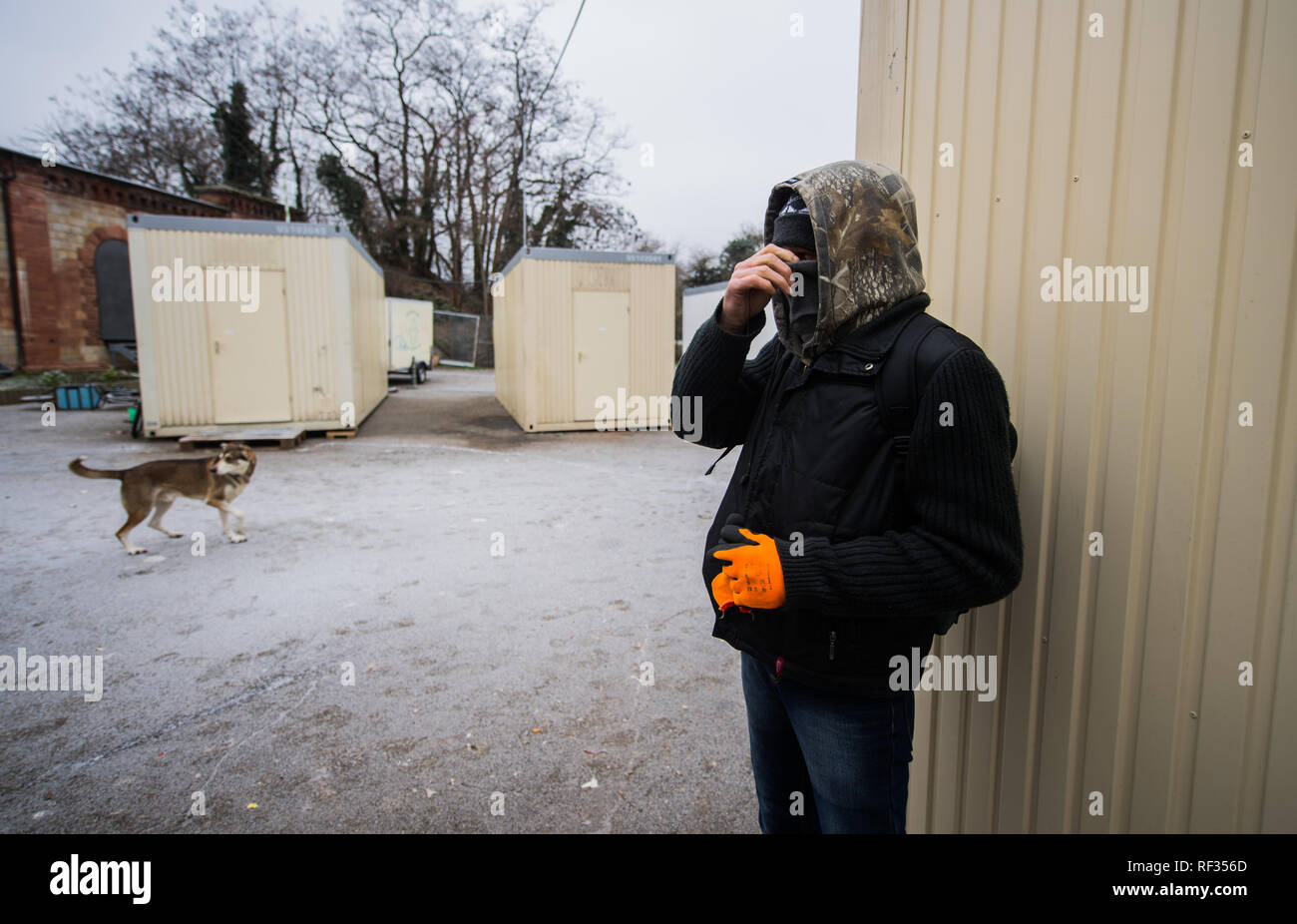 22 January 2019, Rhineland-Palatinate, Mainz: Günni (50) stands between the living containers and pulls his buff upwards as protection against the cold. The father of a daughter (29) spent 22 years in prison, according to his own statement. He's currently dry and off the drugs thanks to the substitute drug Subutex. He prefers to sleep on the street or in empty houses, in the official accommodations there is always trouble, fights, alcohol problems and thefts. Over the winter, the city of Mainz has set up residential containers for the homeless at Fort Hauptstein near the main railway station. Stock Photo