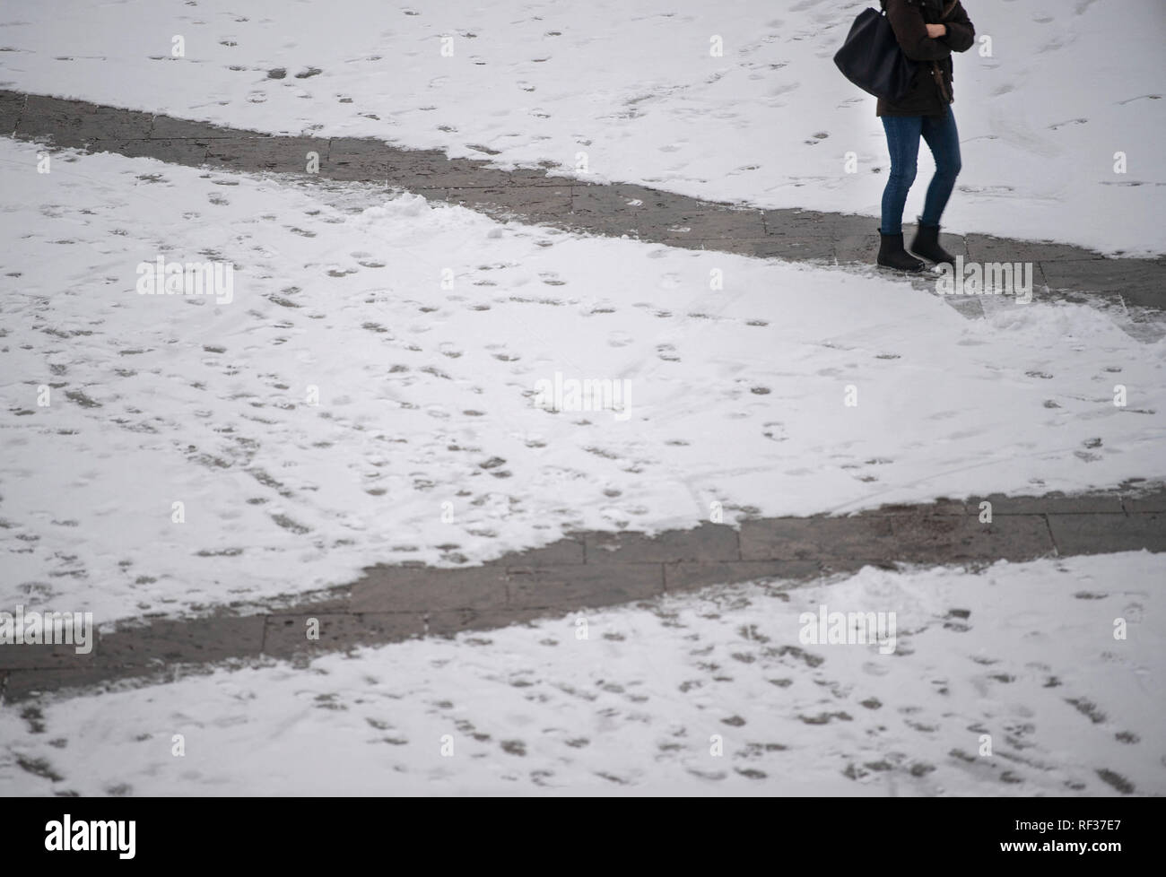 Stuttgart, Germany. 24th Jan, 2019. A woman is walking down a snow-cleared path in downtown. Credit: Marijan Murat/dpa/Alamy Live News Stock Photo