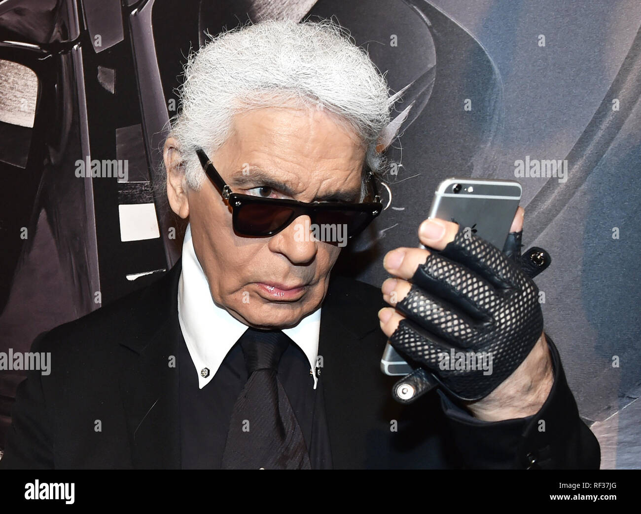 Berlin, Germany. 03rd Feb, 2015. Fashion designer Karl Lagerfeld stands  watching his smartphone at the vernissage for his photo calender 'Corsa Karl  and Choupette' at the Palazzo Italia in Berlin, Germany, 03