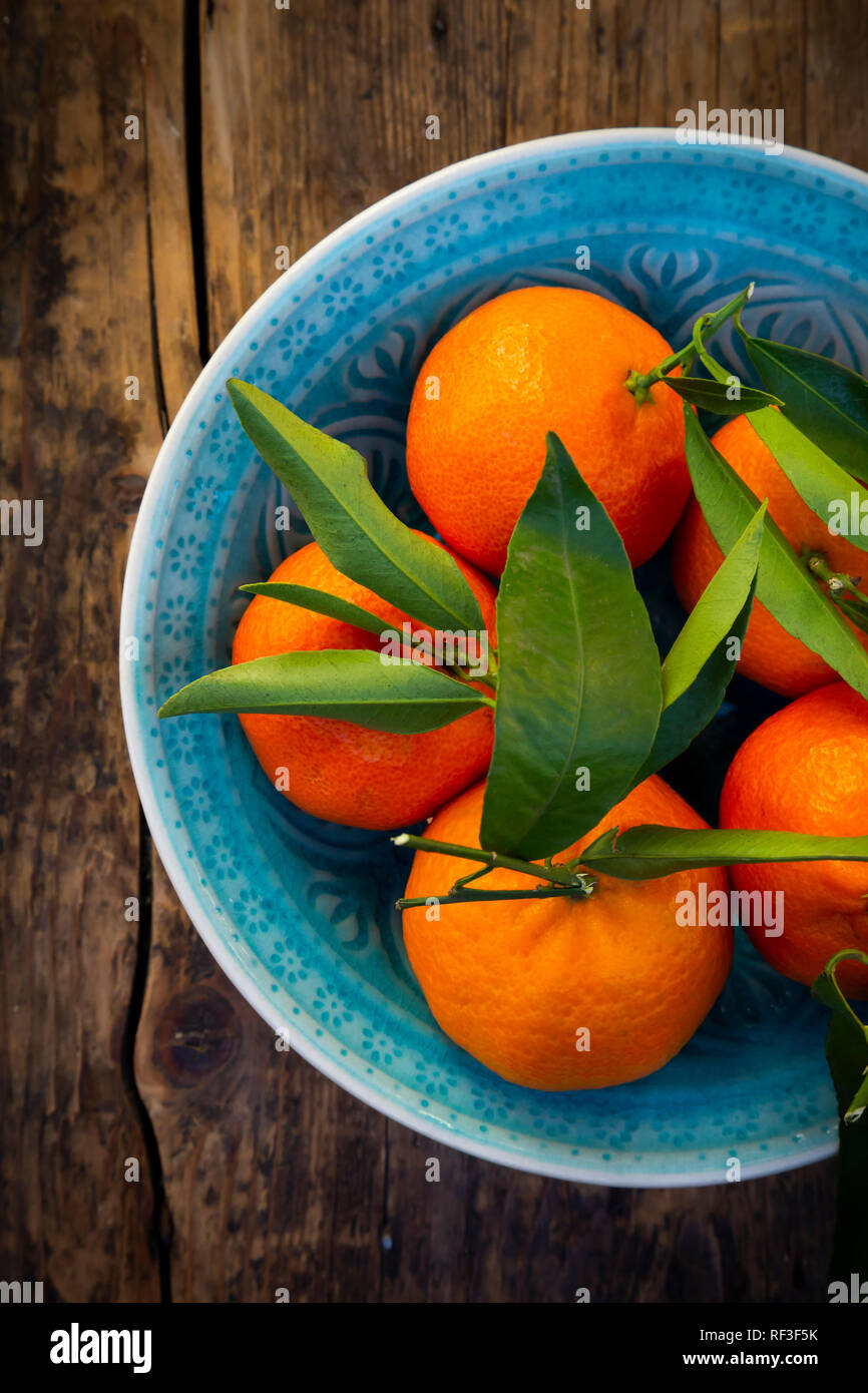 Clementines in bowl on wood, from above Stock Photo