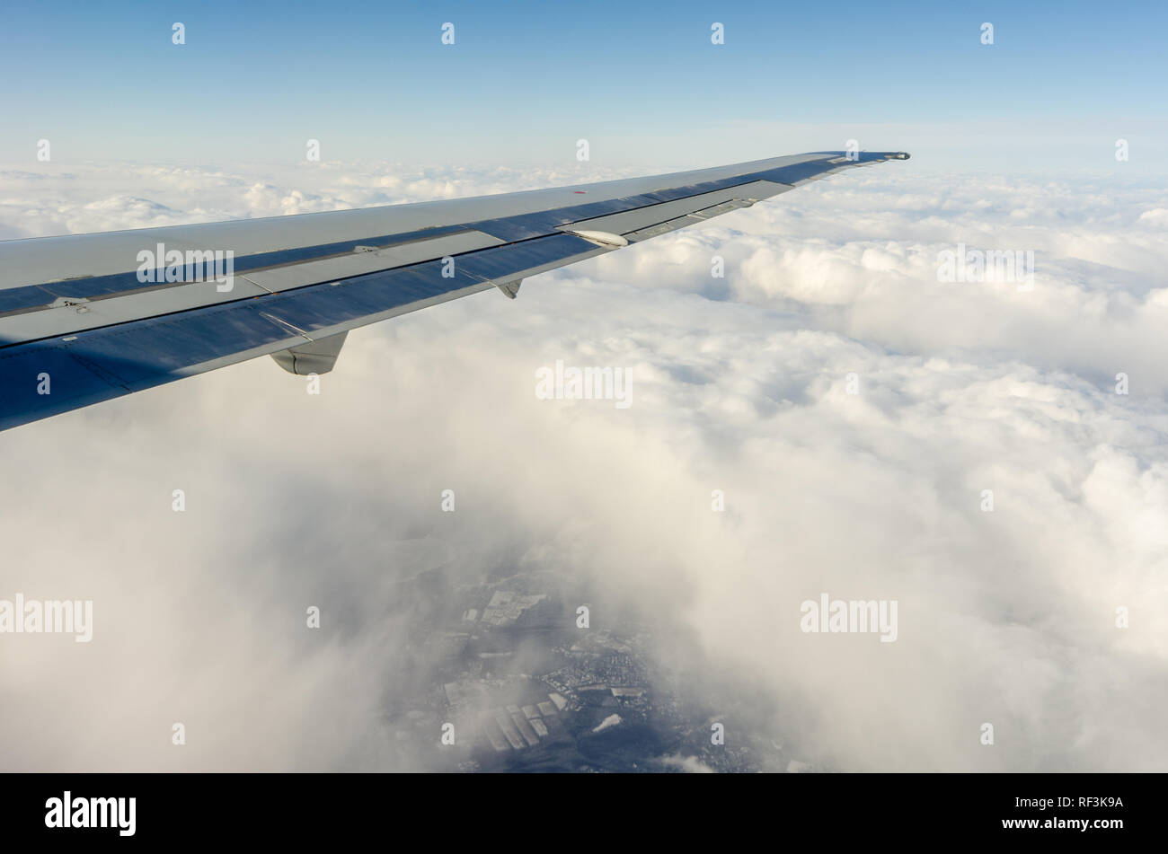 Airplane wing flying above the clouds Stock Photo
