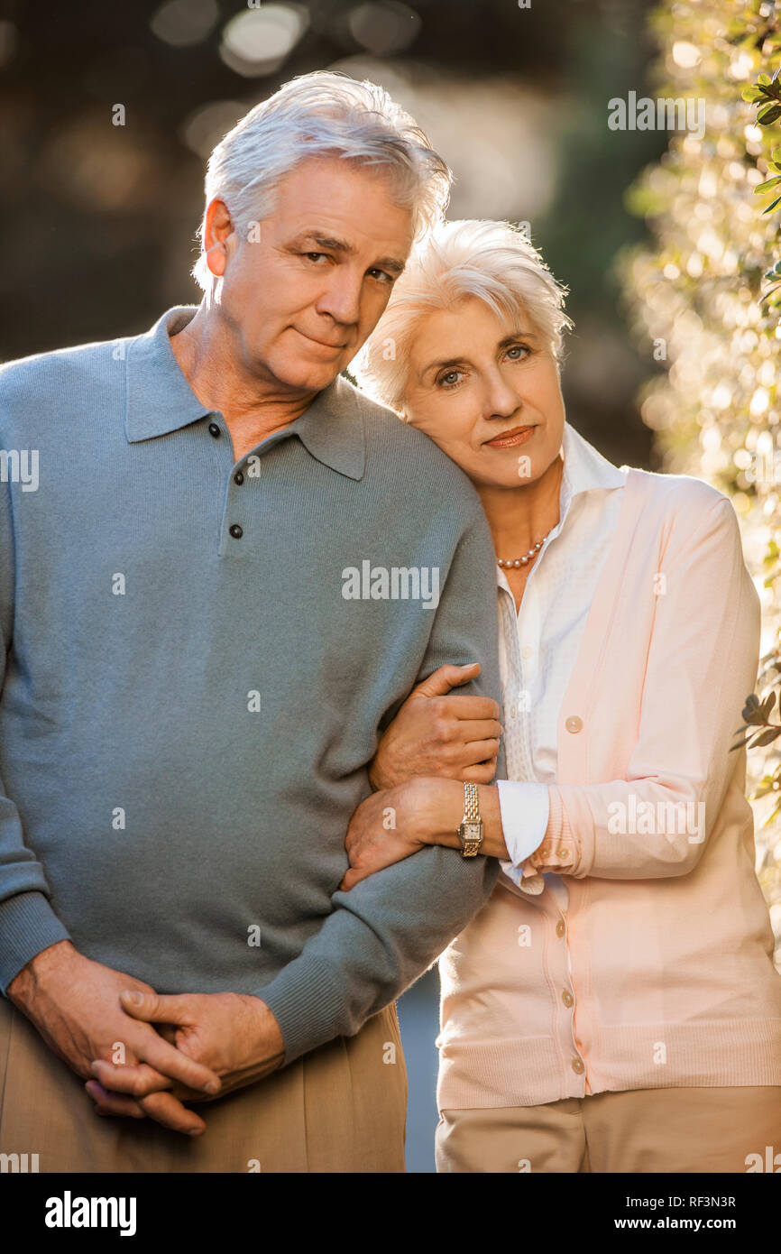 Portrait of a mature couple standing arm in arm. Stock Photo