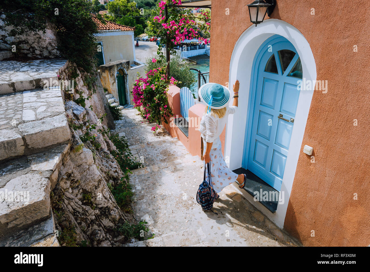 Attractive young fashion woman on summer vacation on Kefalonia Island. Beautiful tanned woman with sun hat exploring small traditional touristy town, Greece, Europe Stock Photo
