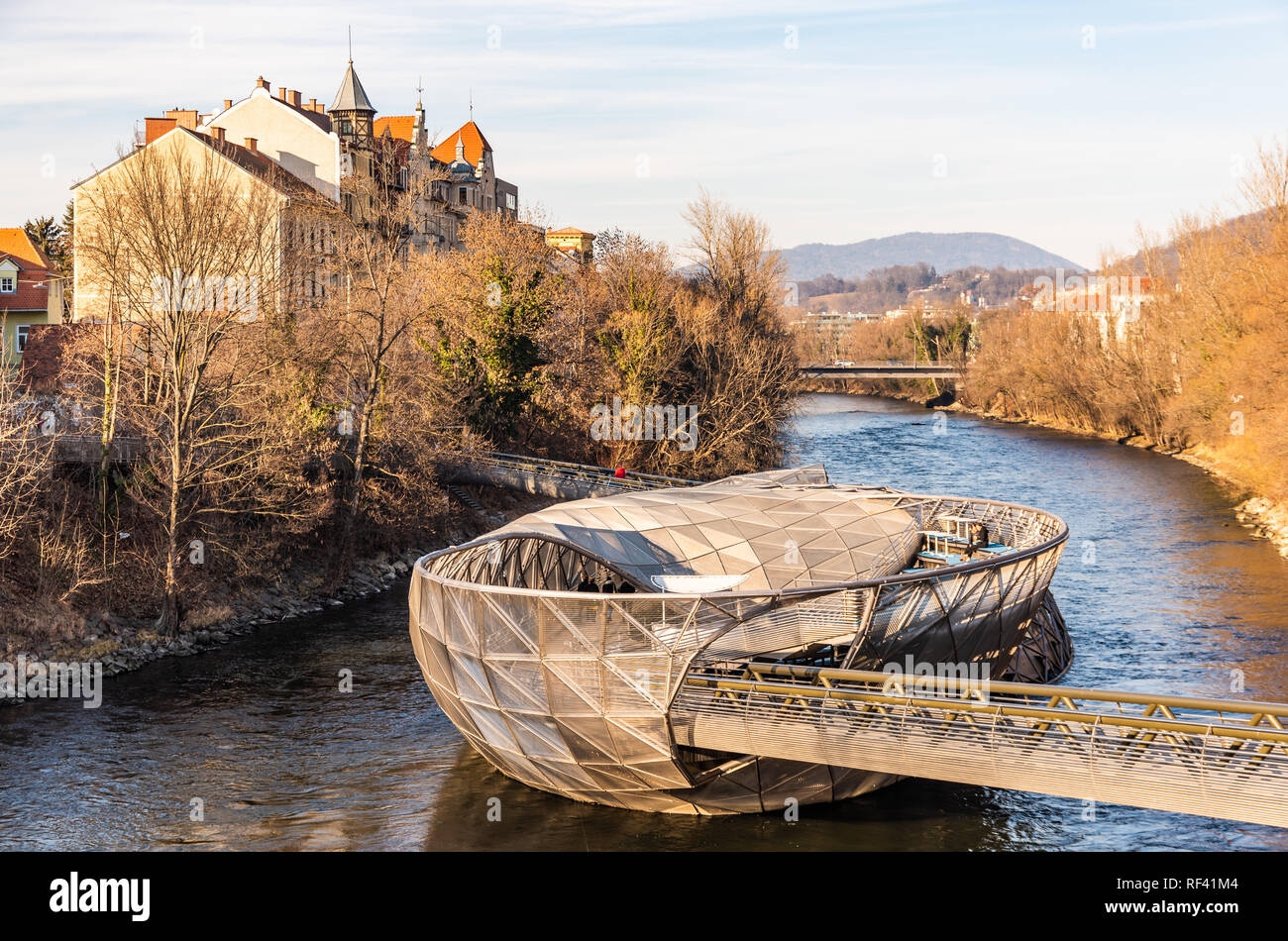Graz, Styria / Austria - 20.01.2019: View at Mur river, Murinsel on bridge, people enjoy beautiful winter sun. Travel destination. Stock Photo