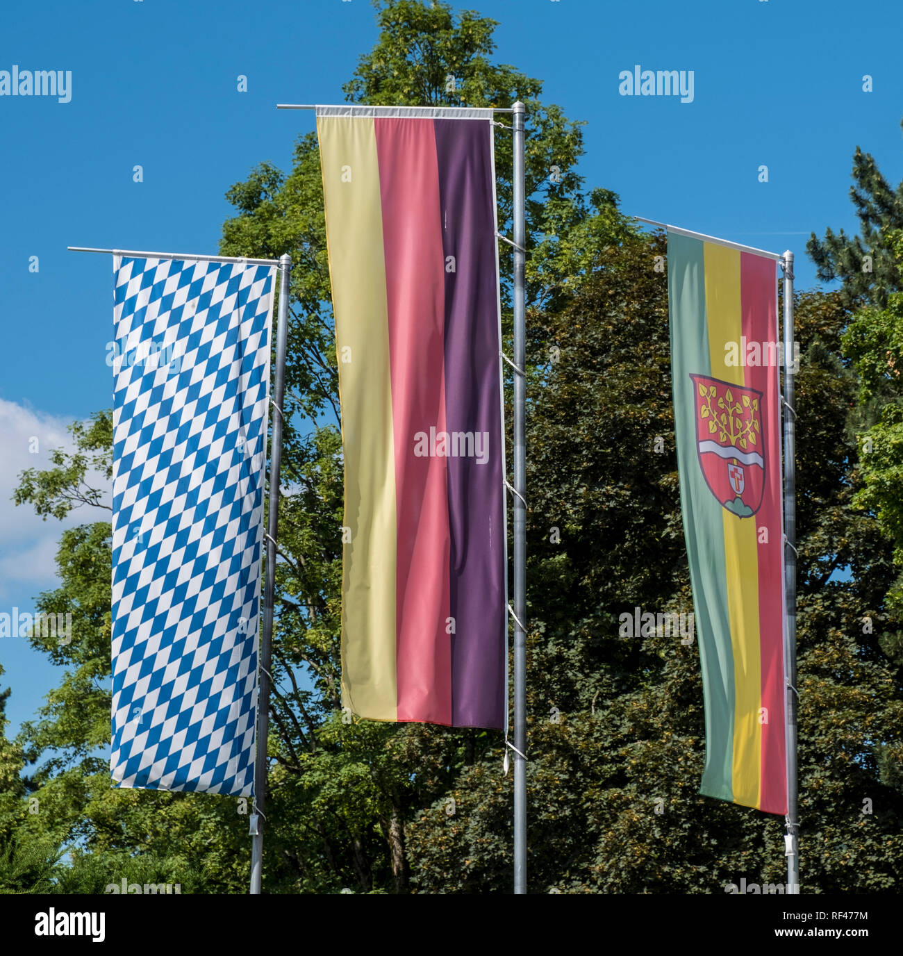 The German, Bavarian and Ruhpolding Flags flying in the Kurpark at Ruhpolding. Upper Bavaria, Germany, Europe Stock Photo