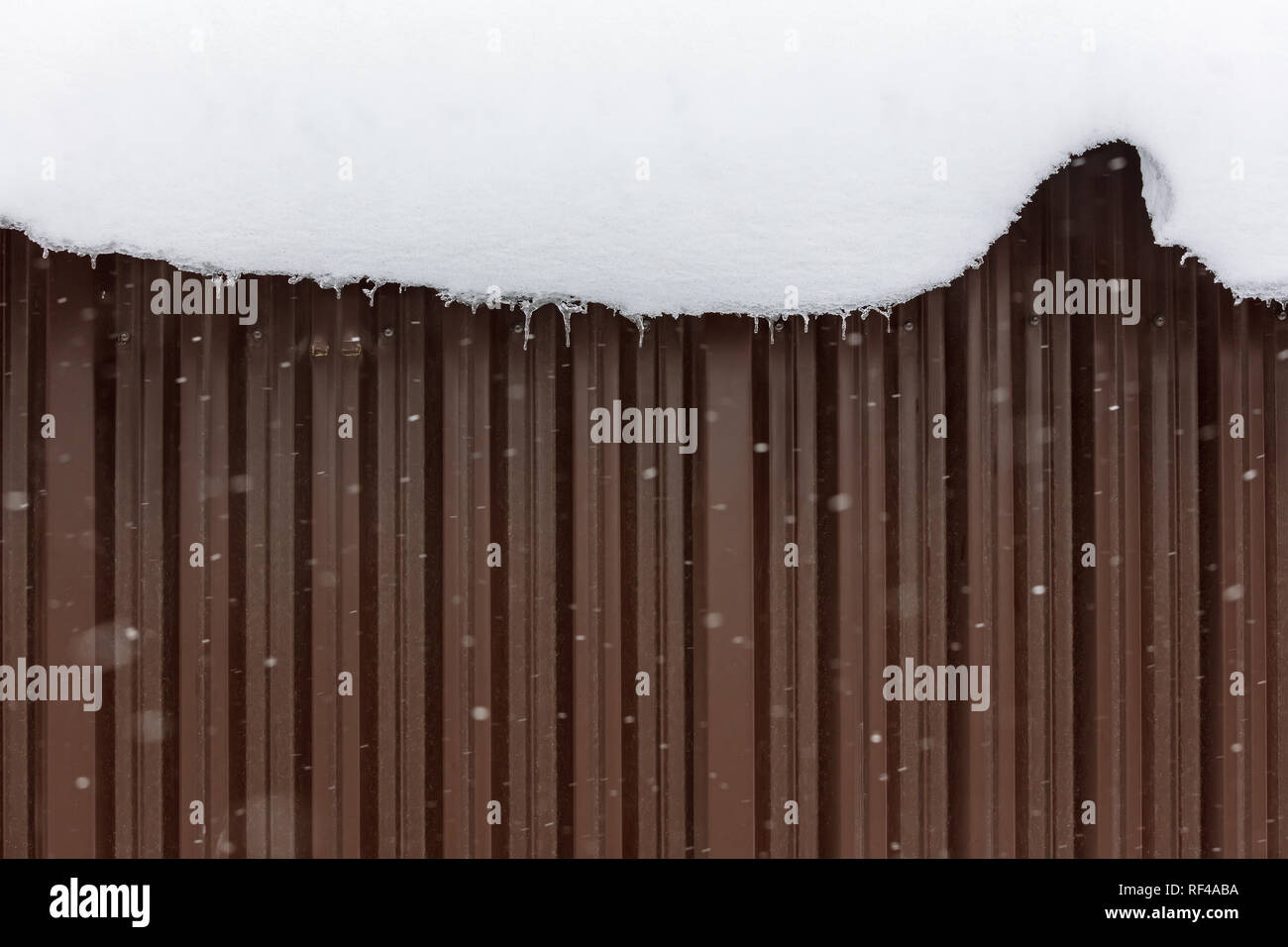 white thick snowdrift slide on roof down at winter day Stock Photo