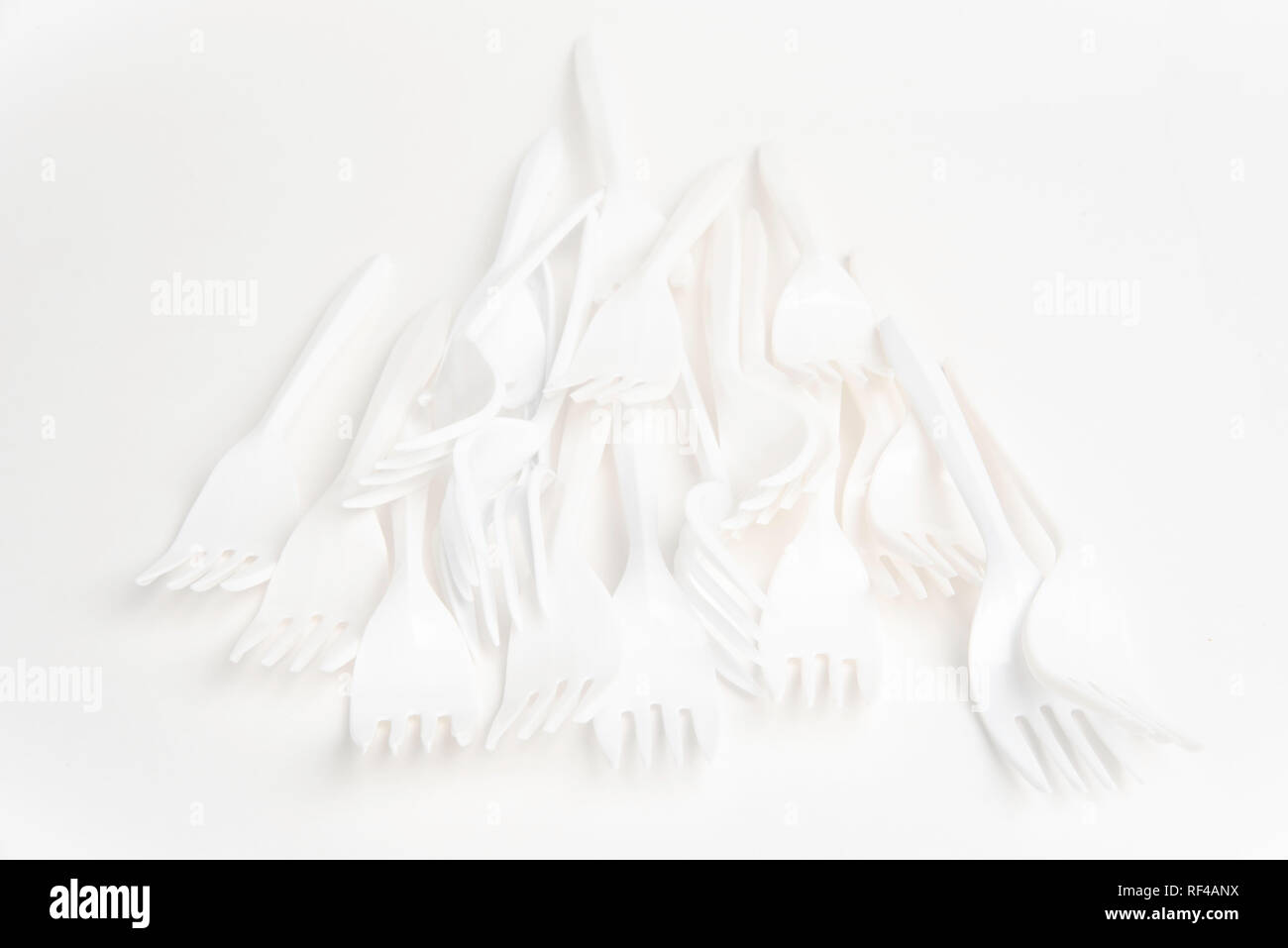 A bunch of white disposable singleuse plastic forks commonly available