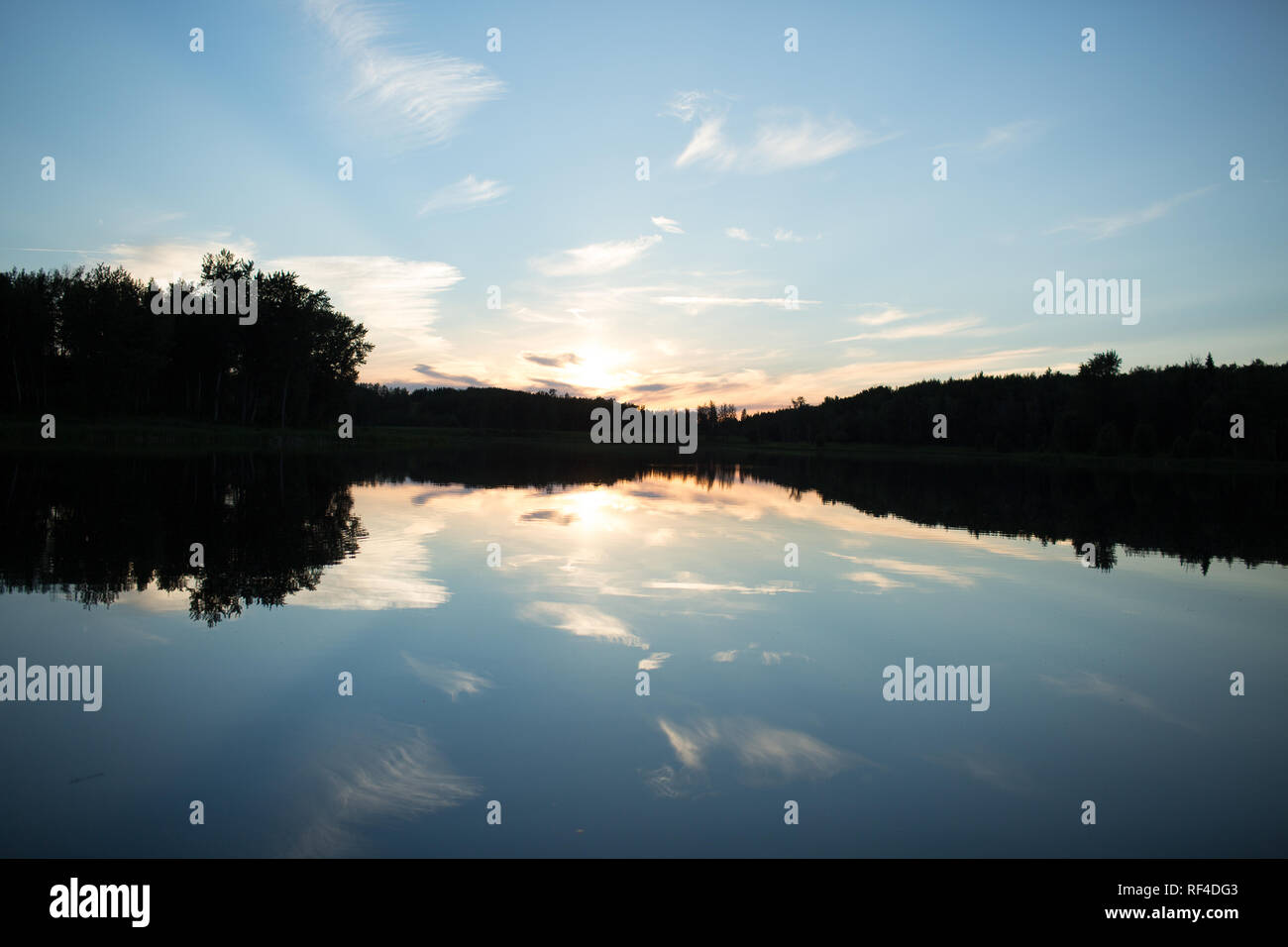 blue sky and clouds reflected in water of small lake Stock Photo - Alamy