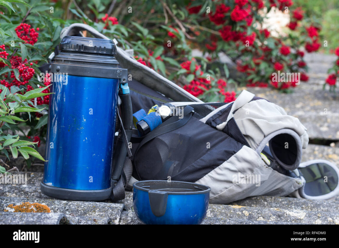 Thermos, backpack and headlamp. Tourist equipment. Cup with a drink