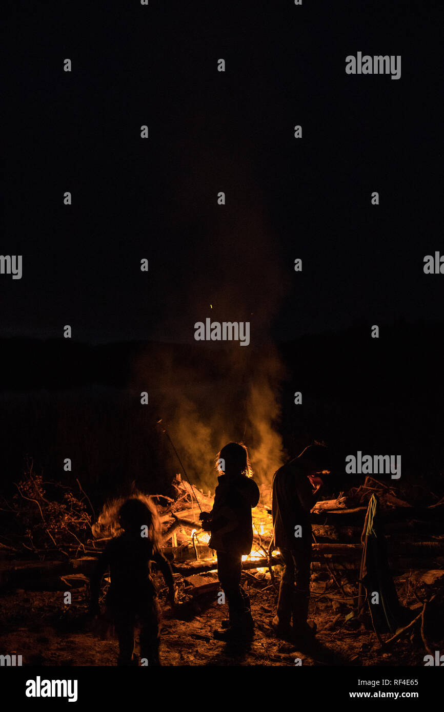 silhouette of children standing near bonfire Stock Photo