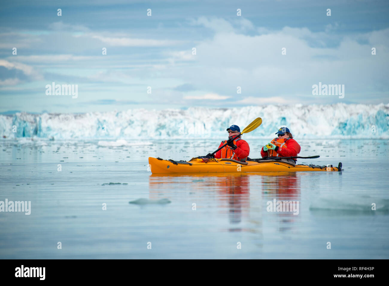NORDEAUSTLANDET, Svalbard — Two tourists kayak through the Arctic waters near Nordaustlandet, Svalbard, Norway. Kayaking offers an immersive experience in the region's icy seas and glacial landscapes. Svalbard, an archipelago situated in the Arctic Ocean, is known for its dramatic fjords, glaciers, and unique wildlife. This form of tourism highlights the pristine beauty and fragile ecosystems of the polar environment. Stock Photo