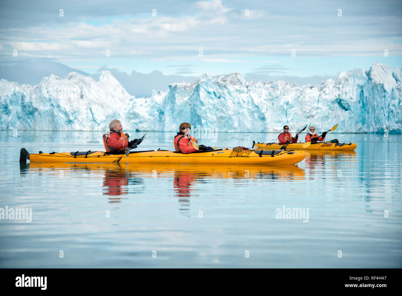 NORDEAUSTLANDET, Svalbard, Norway — Kayaking tourists navigate the icy waters of the Arctic Ocean, with a massive glacier in the background. This region of Svalbard is known for its dramatic glacial landscapes and rich wildlife. Kayaking offers an intimate way to experience the Arctic environment, showcasing its pristine beauty and fragile ecosystems. The archipelago of Svalbard is located in the Arctic Ocean, midway between mainland Norway and the North Pole. Stock Photo