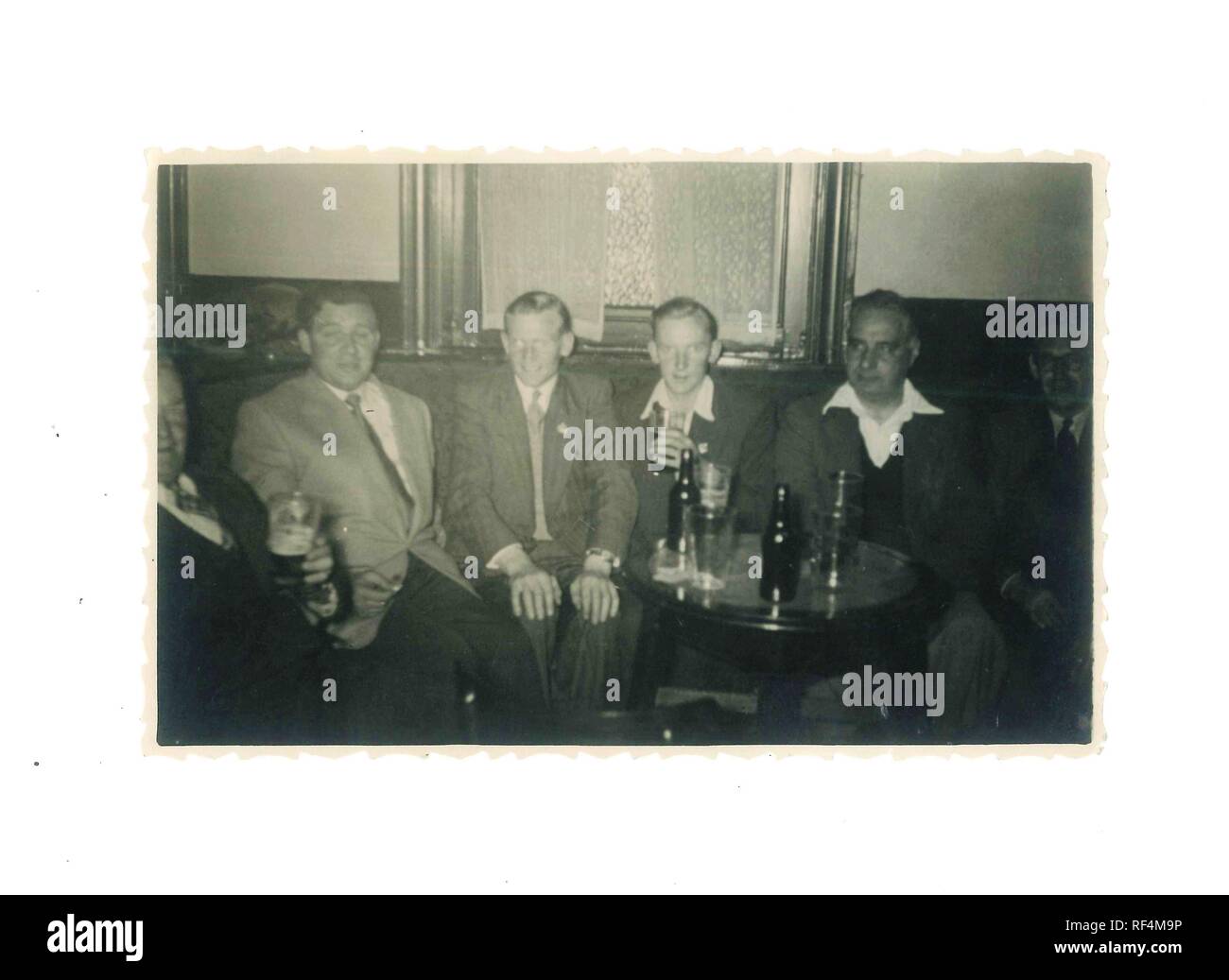 Vintage black and white photo of old army pals having a drink in a pub 1960s - Social History Stock Photo