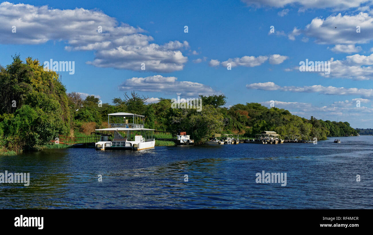 Tourist river cruise boats awaiting passengers on the Zambezi river, Chobe National Park, Botswana. Stock Photo