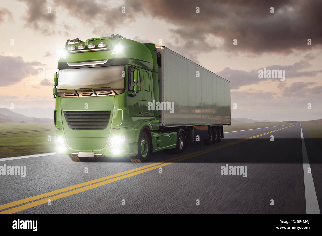 Green truck with a trailer driving on a remote highway through a landscape at dusk Stock Photo