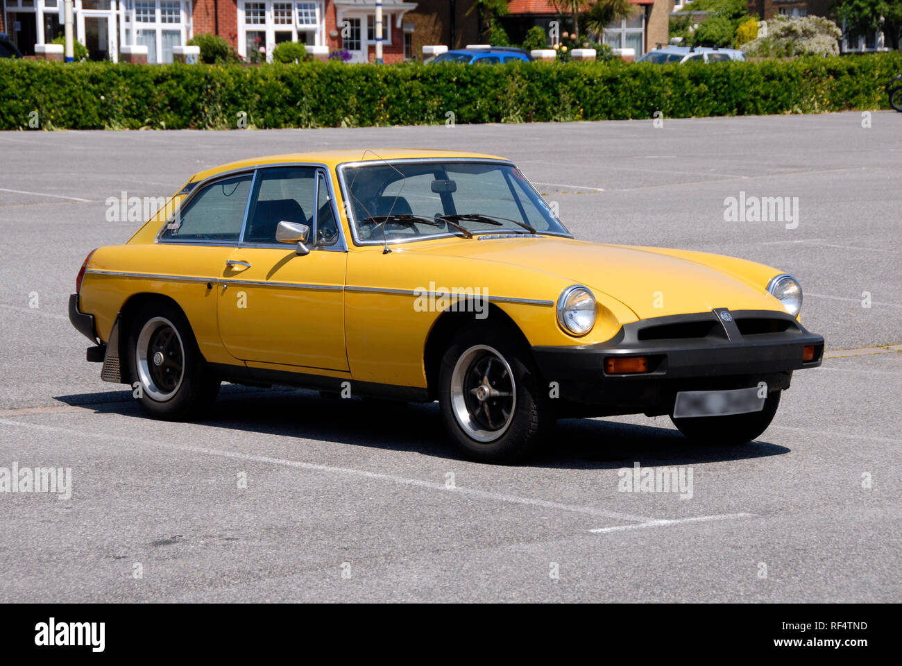 Bright yellow MG BGT sports car alone in car park, Eastbourne, East Sussex, England Stock Photo