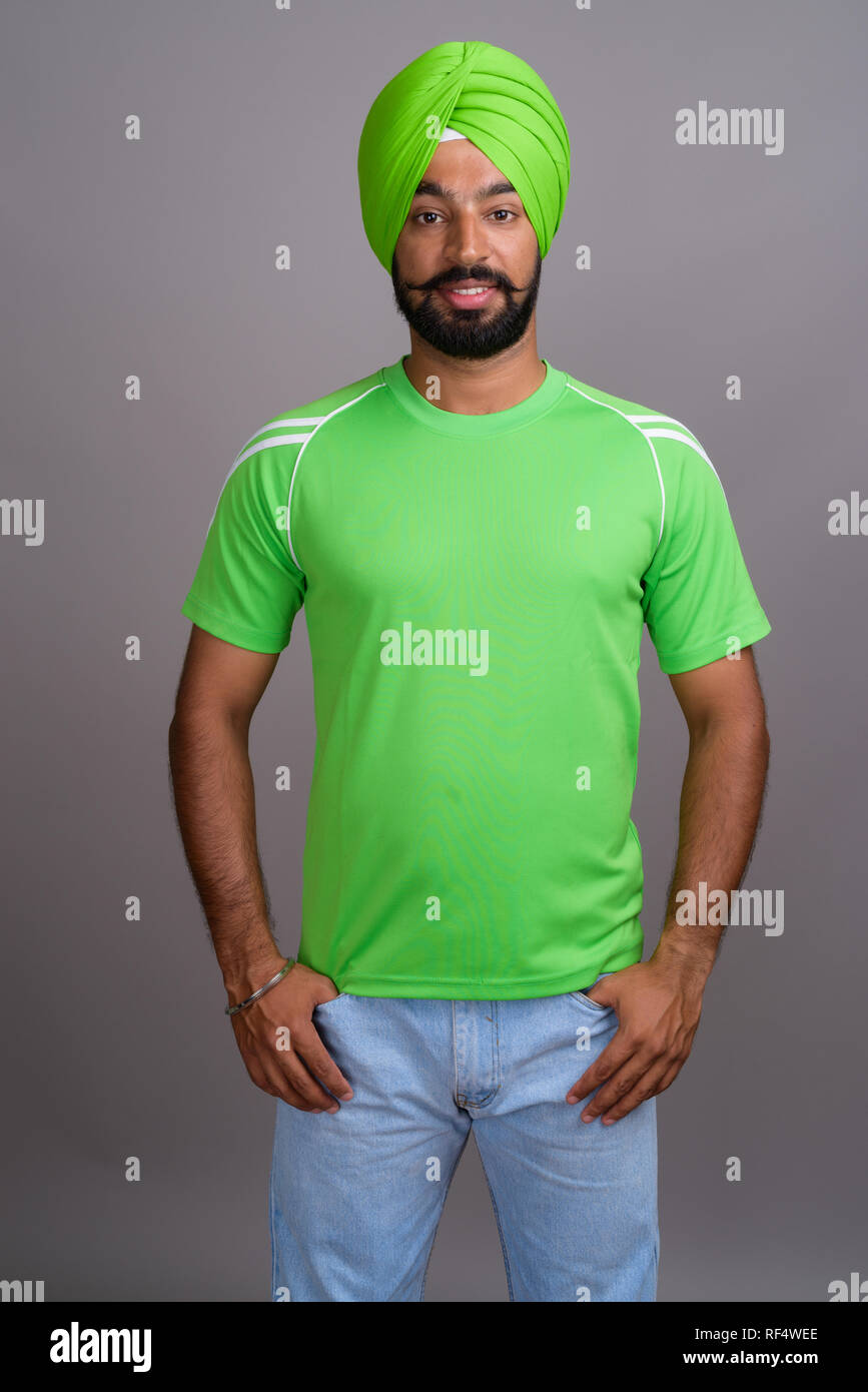 Young handsome Indian Sikh man wearing turban and green shirt Stock Photo
