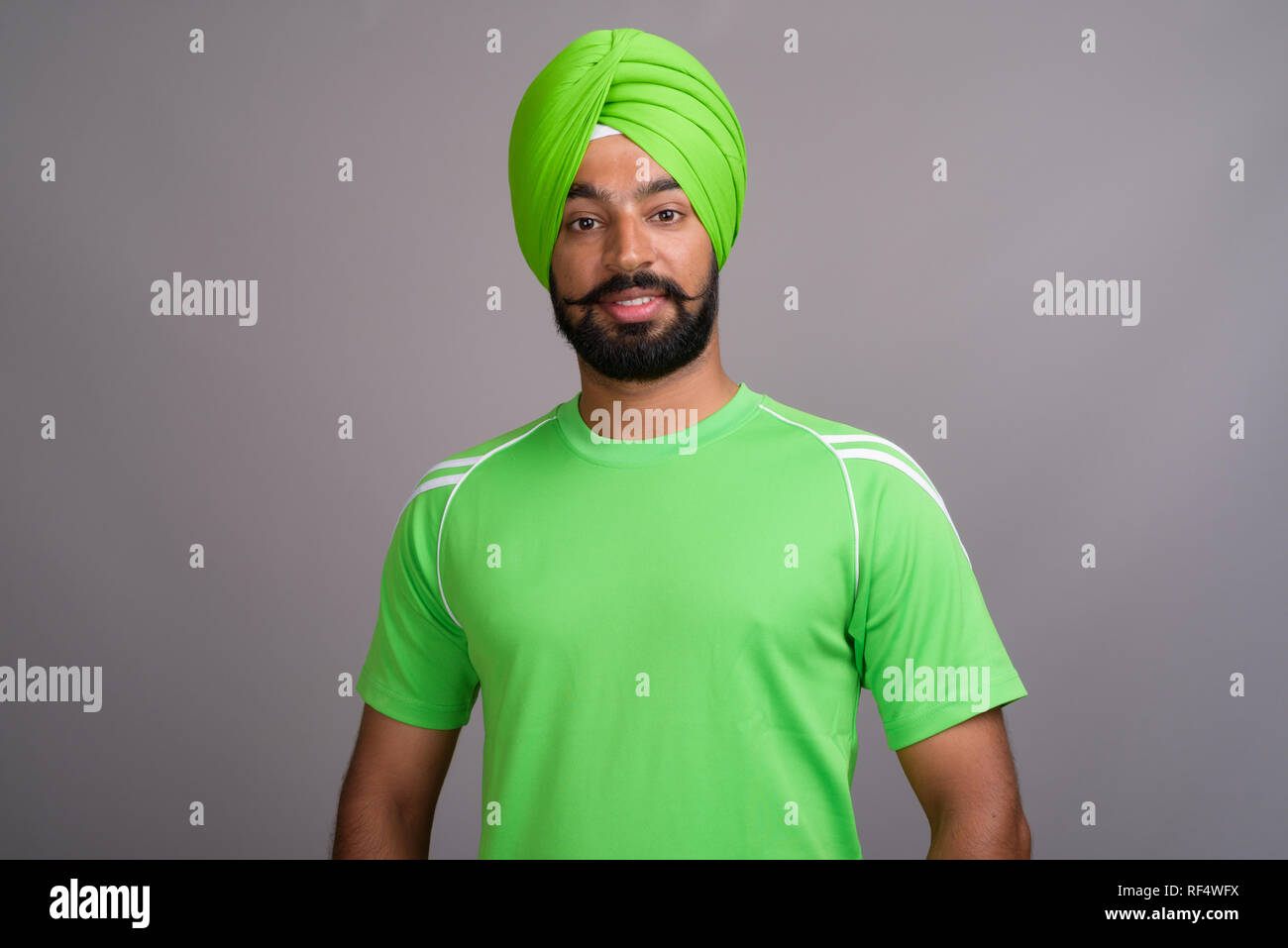 Young handsome Indian Sikh man wearing turban and green shirt Stock Photo