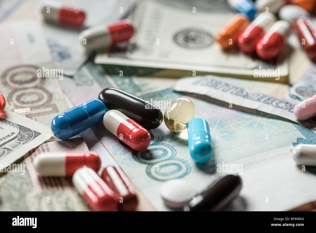 selective focus of multicolored pills on banknotes background Stock ...
