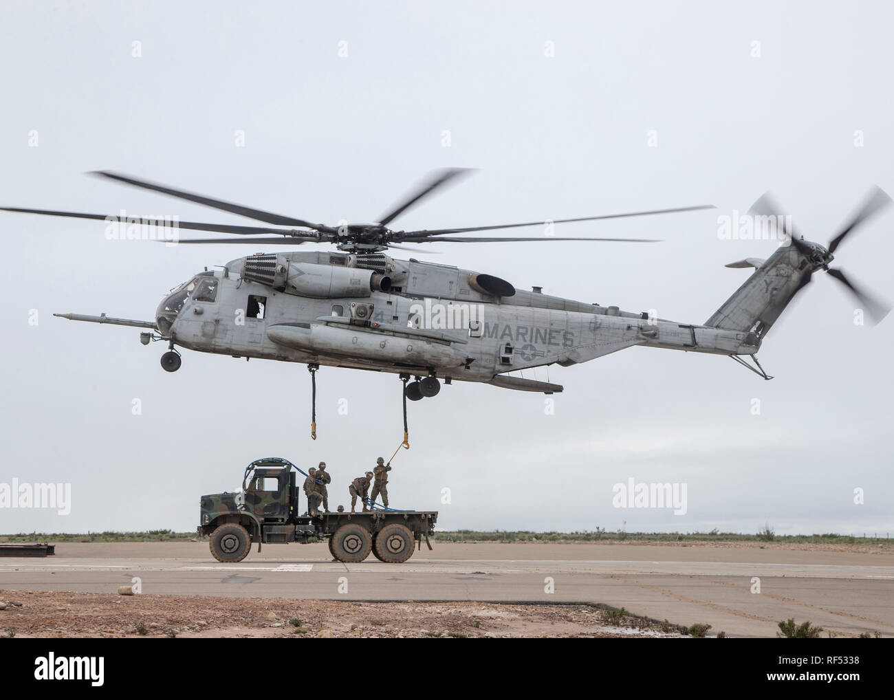 MARINE CORPS AIR STATION MIRAMAR, Calif.- U.S. Marines with 1st Transportation Support Battalion (TSB), 1st Marine Logistics Group (MLG), hook a Medium Tactical Vehicle Replacement (MTVR) to a CH-53E Super Stallion with Marine Heavy Helicopter Squadron (HMH) 462, Marine Aircraft Group (MAG) 16, 3rd Marine Aircraft Wing (MAW) at Marine Corps Air Station Miramar, Calif., Jan. 16. Marines from HMH-462 and 1st MLG conducted an external lift of an MTVR to improve their support capabilities and exercise the aircraft’s limit of 36,000 pounds. (U.S. Marine Corps photo by Lance Cpl. Clare J. McIntire) Stock Photo