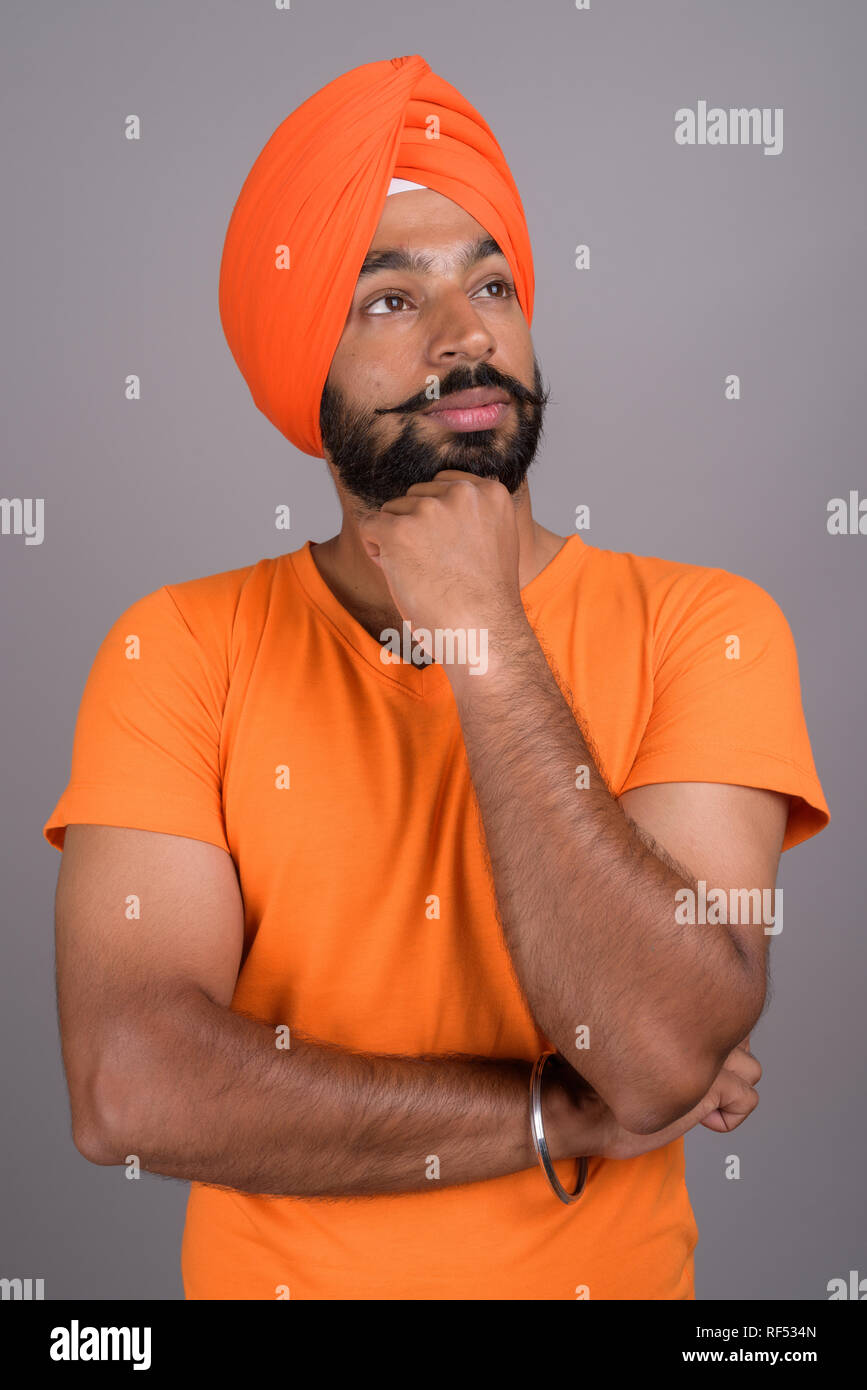 Indian Sikh man wearing turban and orange shirt Stock Photo