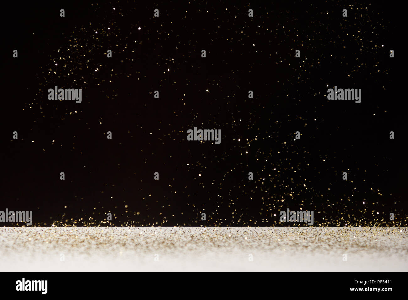white table with bright shiny sparkles isolated on black Stock Photo