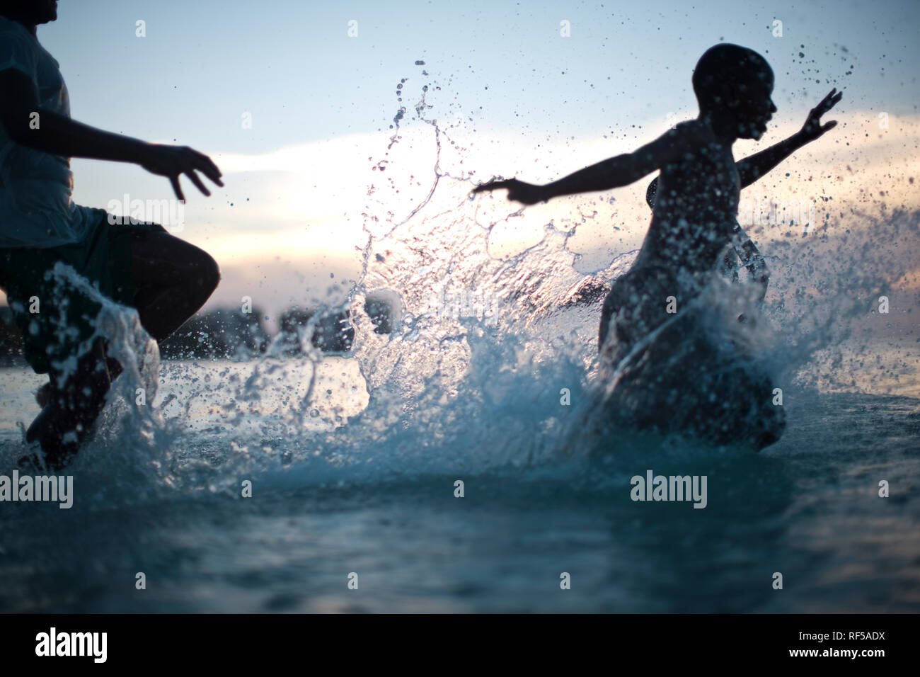 Boys splashing and playing in the sea Stock Photo - Alamy