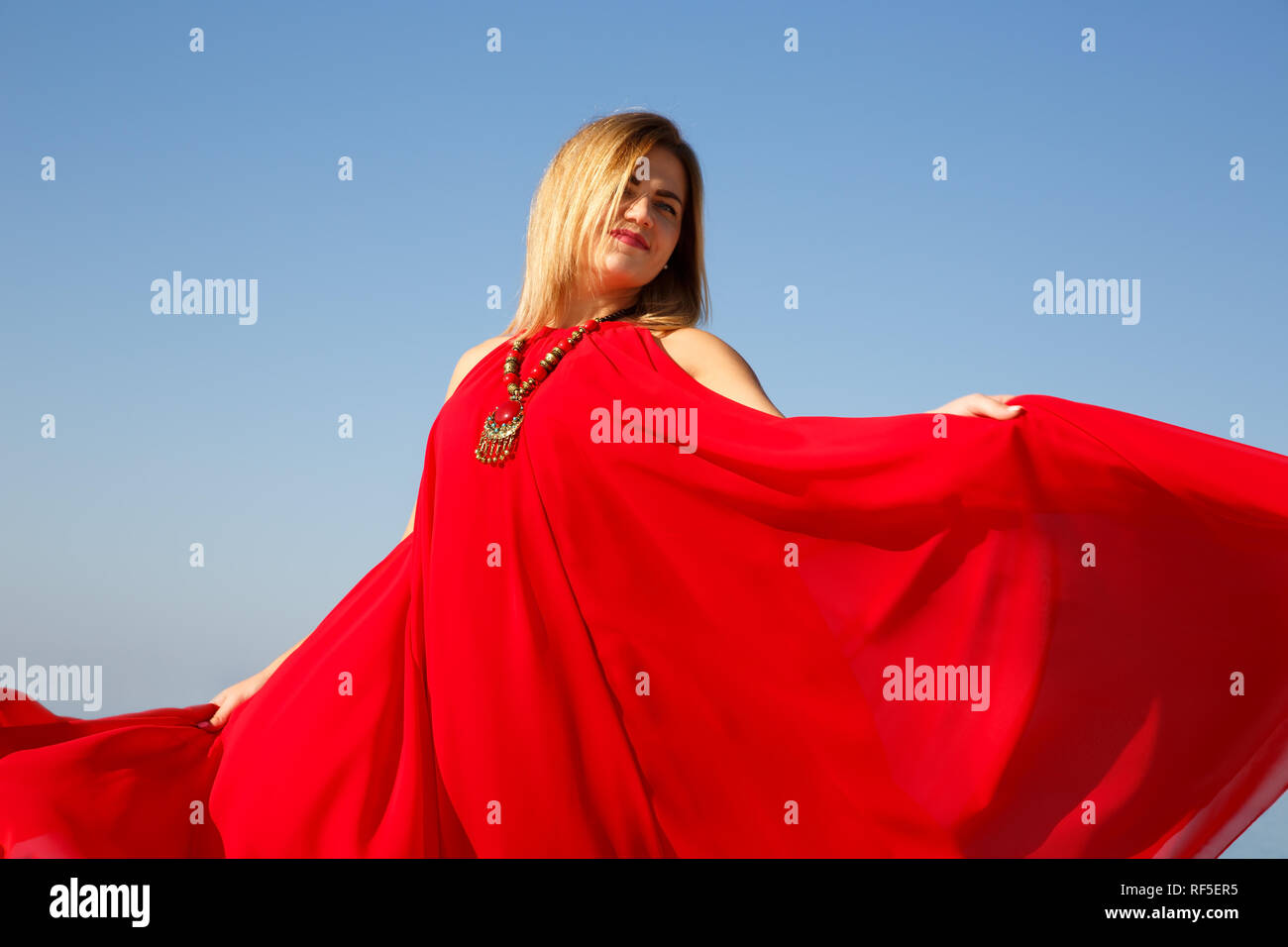 Woman in the red dress with necklace close up picture. Stock Photo