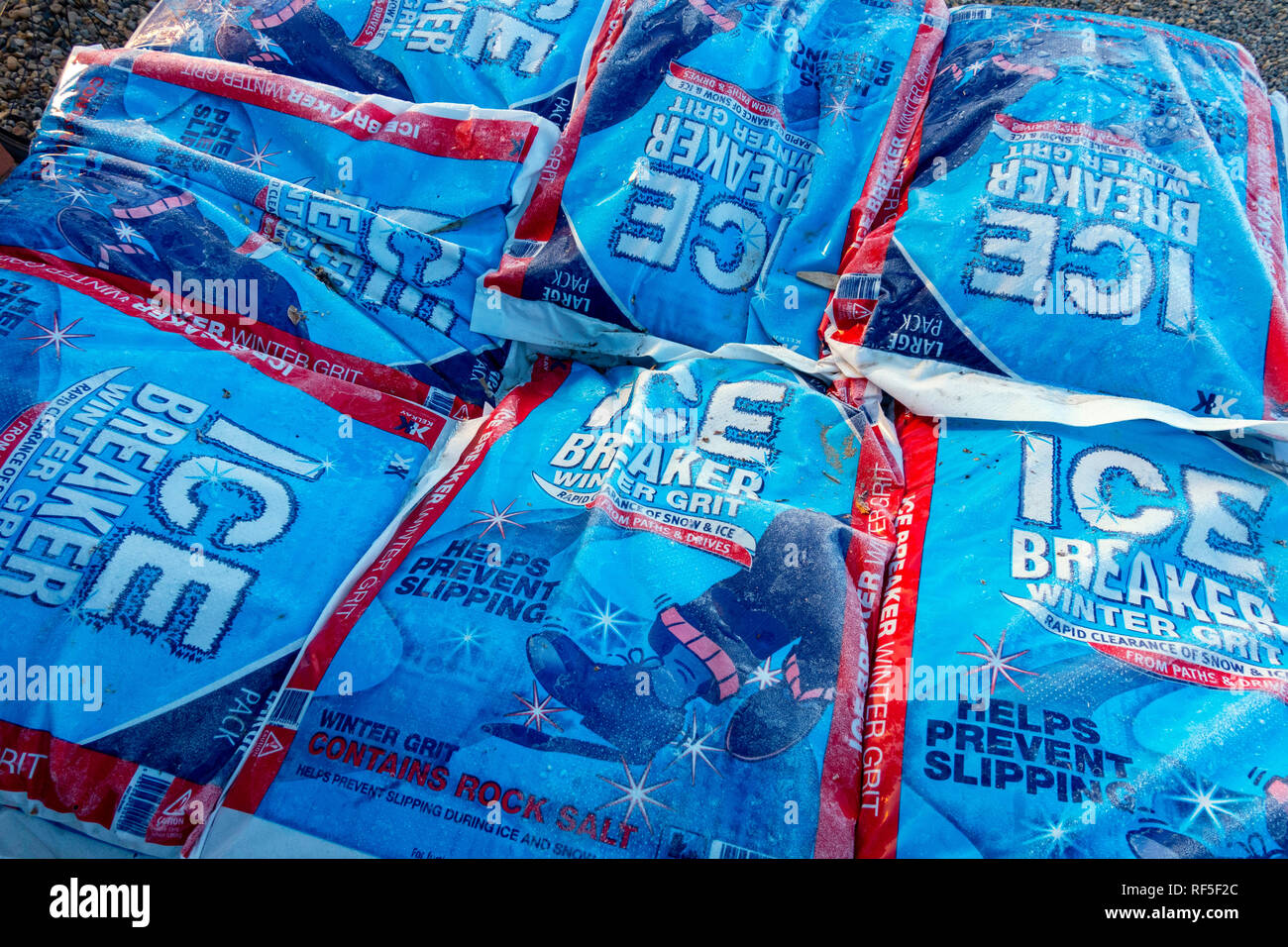 Stack of bags of Ice Breaker winter grit for clearing pathways and reducing the risk of dangerous slips, covered in frost and for sale in a Yorkshire  Stock Photo