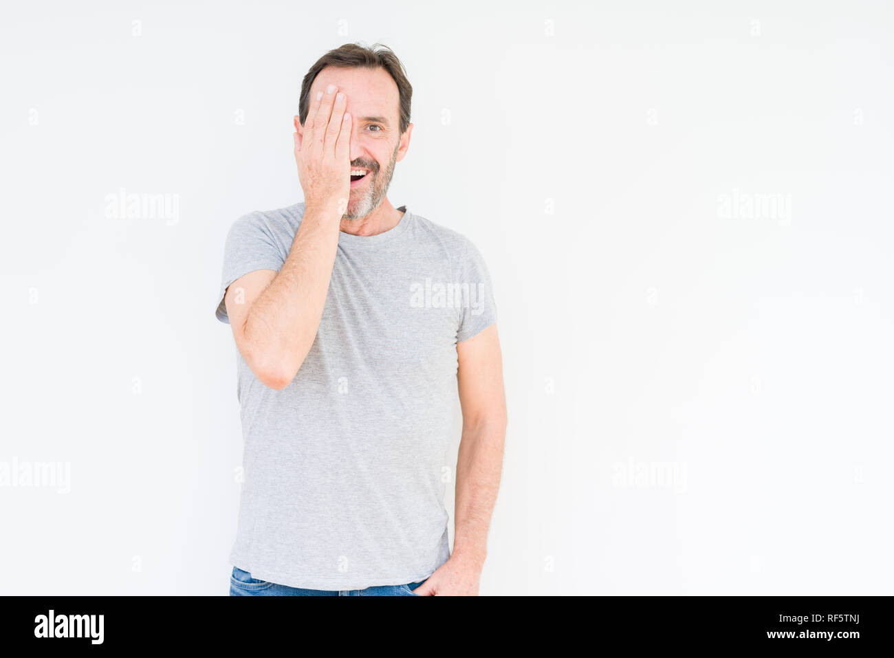 Handsome senior man over isolated background covering one eye with hand ...