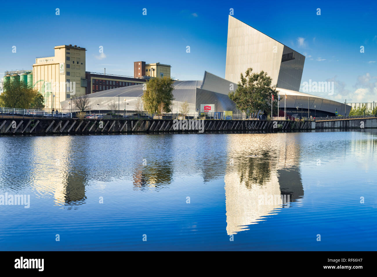 November 2 2018: Salford Quays, Manchester, UK - Imperial War Museum North, reflected in the deep blue water of the Manchester Ship Canal, on a beauti Stock Photo