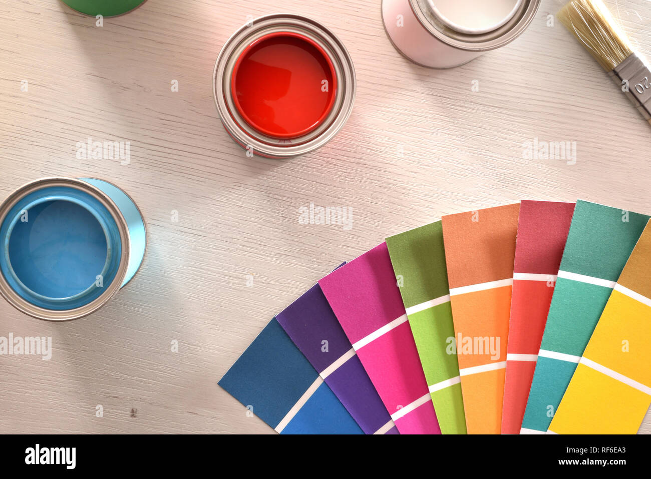 Colorful paint pots open and color palette on white table for renovation of materials. Top view. Horizontal composition. Stock Photo