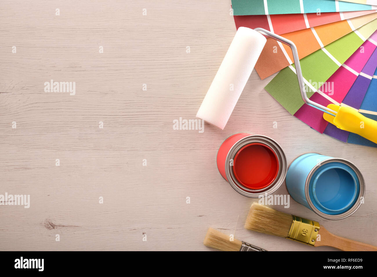 Two red and cyan paint pots open and color palette on wood table for renovation of materials. Top view. Horizontal composition. Stock Photo