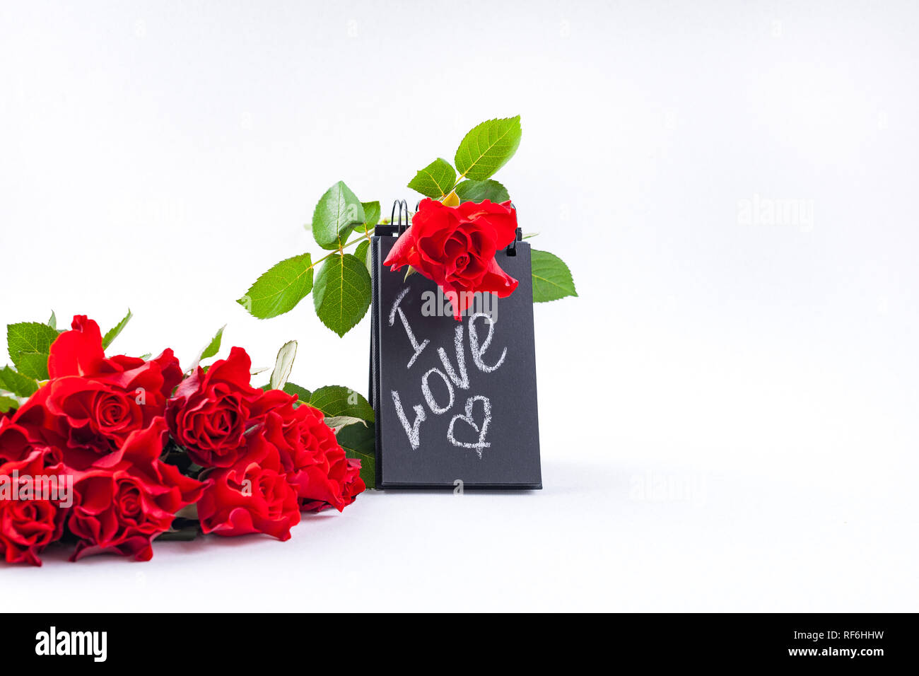 A bouquet of red roses and a letter with the text of love. Gift and flowers  on a white background. The concept of lovers day and mother's day Stock  Photo - Alamy