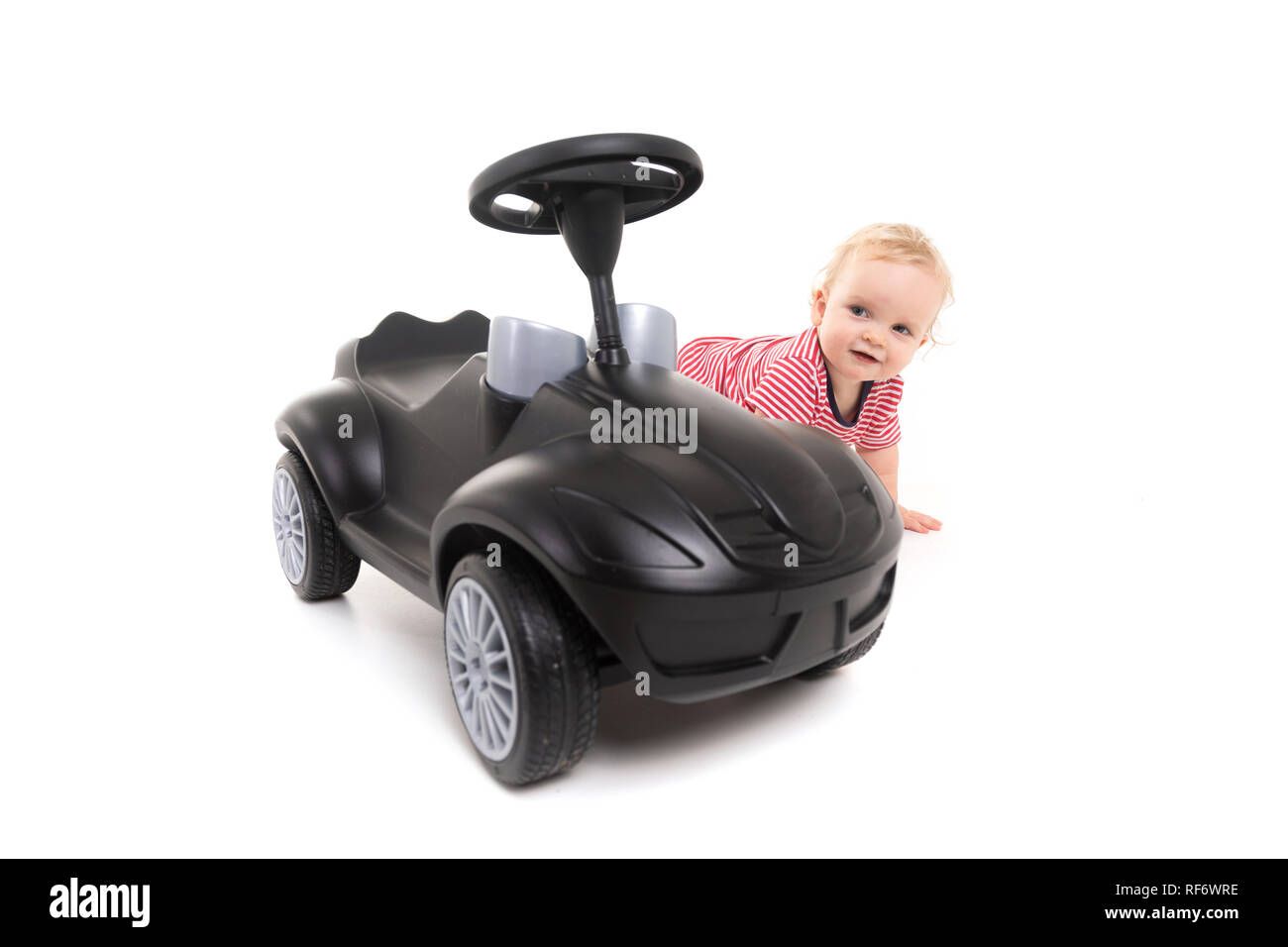 Baby next to Black toy car isolated on white background Stock Photo - Alamy