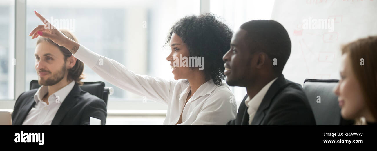 African woman raise hand ask question during seminar at boardroom Stock Photo