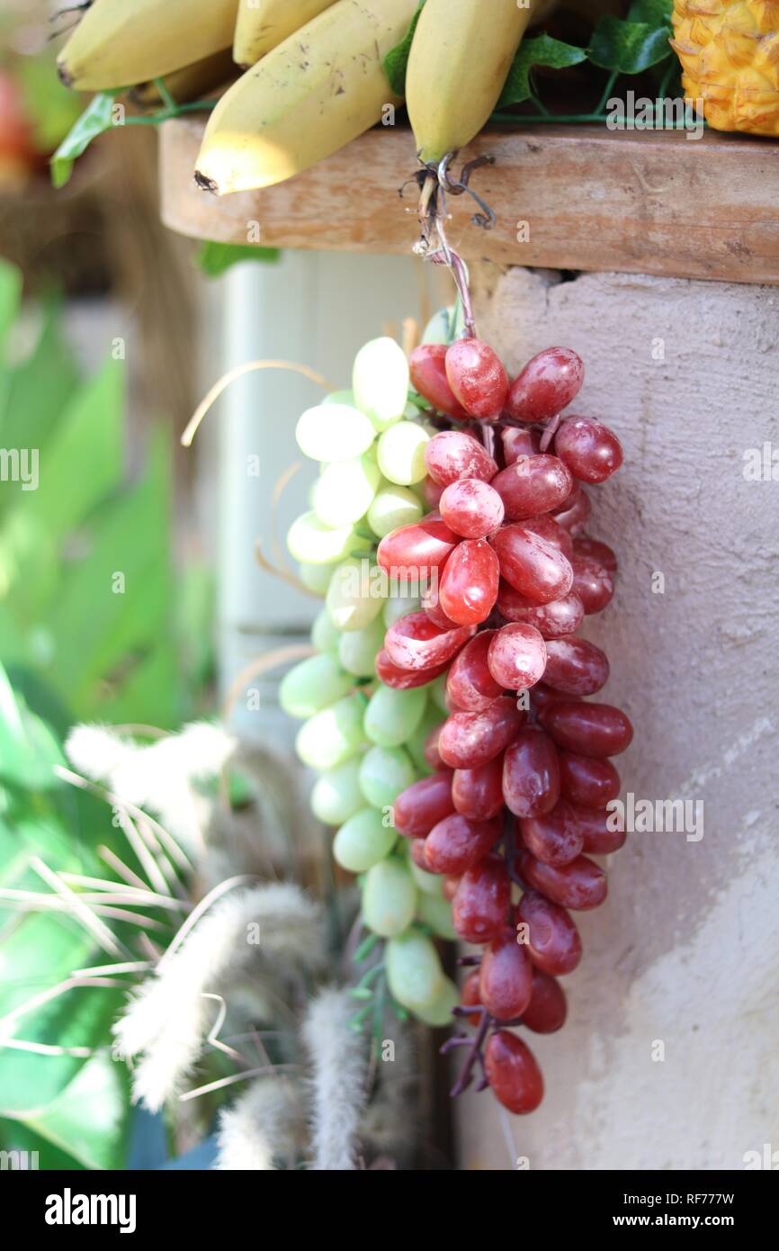 Display of a bunch of grapes next to other fruits Stock Photo