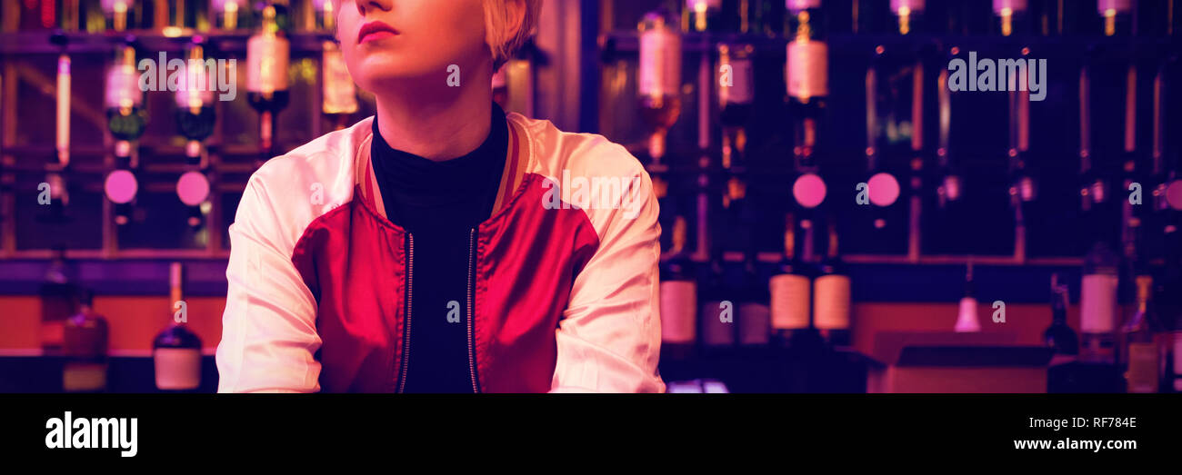 Female bartender standing at bar counter Stock Photo