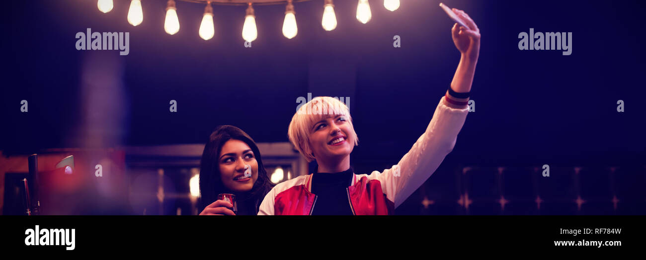 Smiling friends taking a selfie while having wine Stock Photo