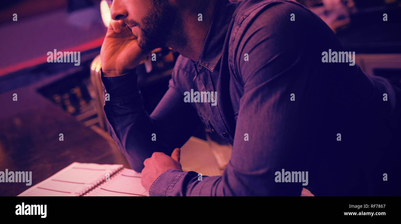 Bartender talking on mobile phone at counter Stock Photo