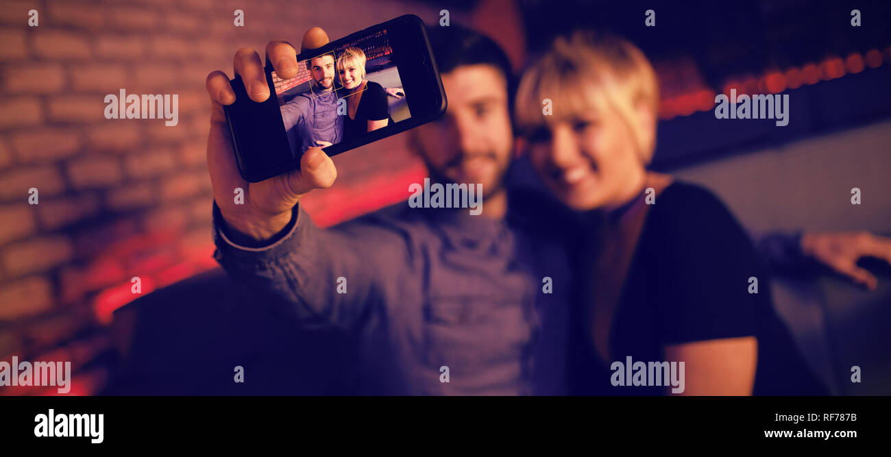 Couple taking selfie on mobile phone in bar Stock Photo
