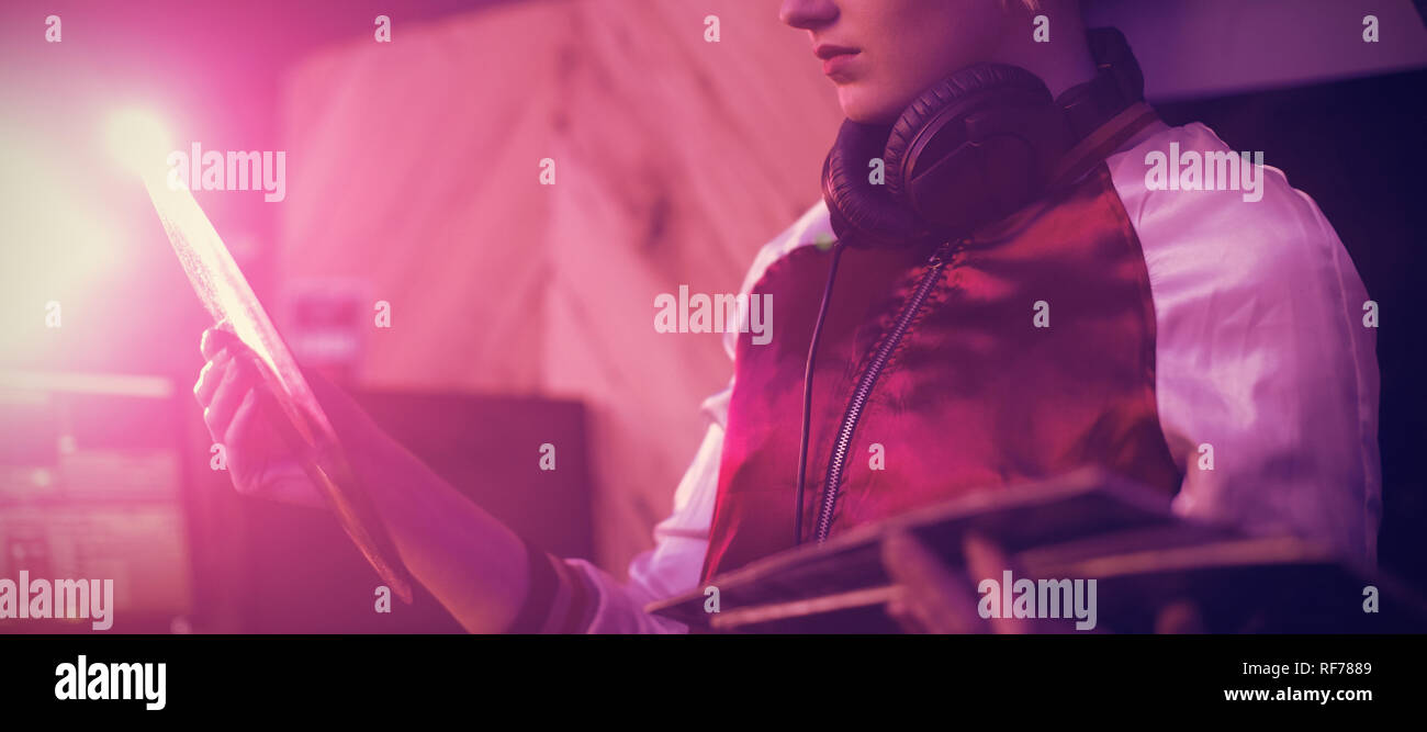 Female dj holding a vinyl disc record in bar Stock Photo