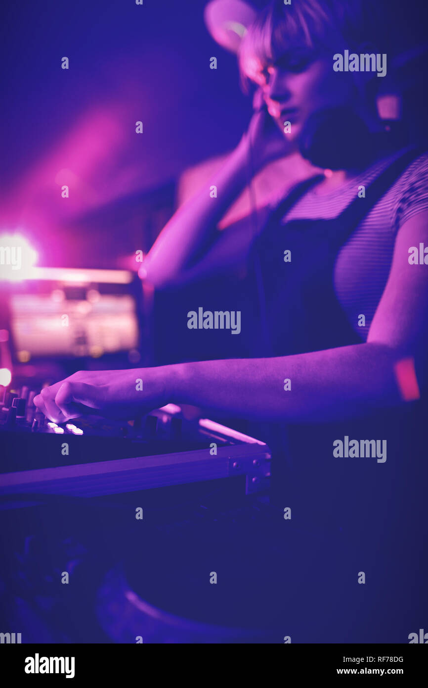 Female dj listening to headphones while playing music Stock Photo Alamy