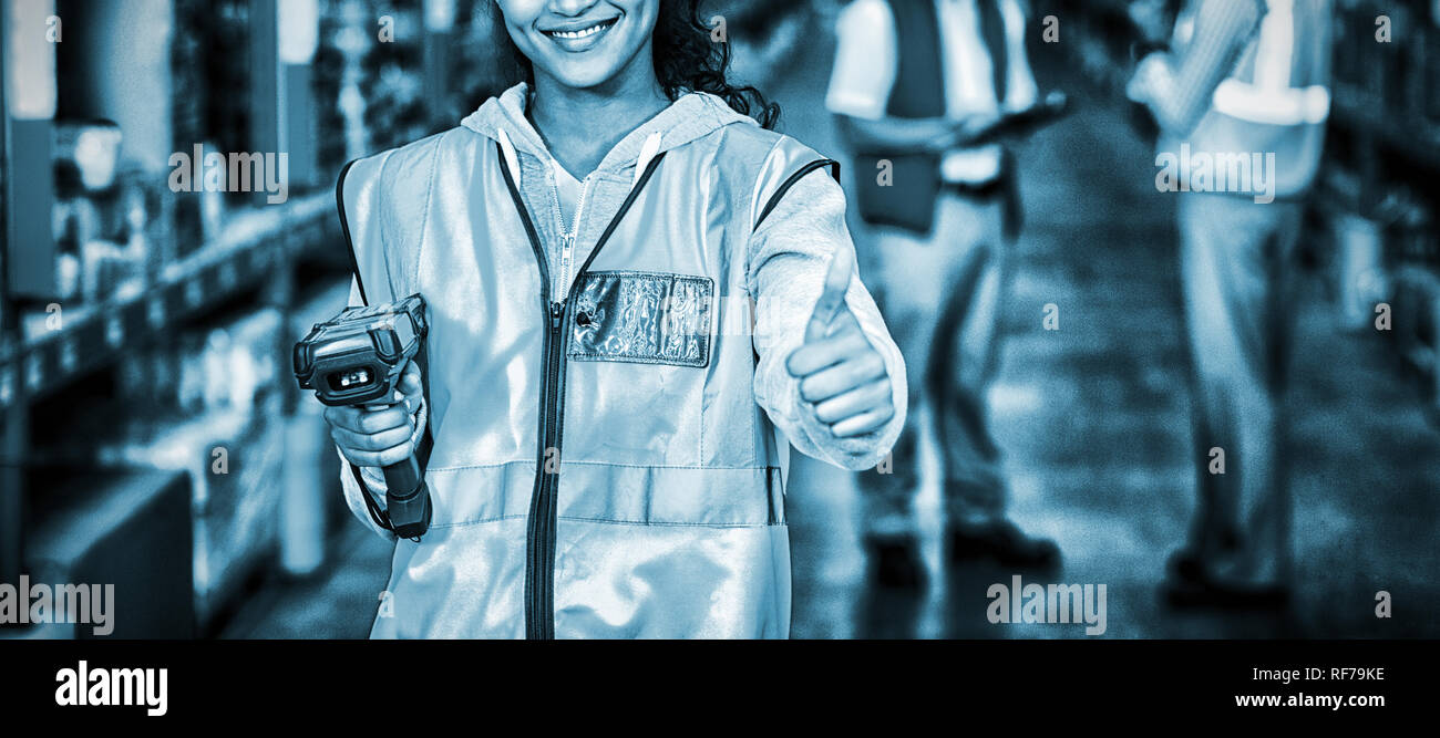 Smiling female worker with thumb up Stock Photo