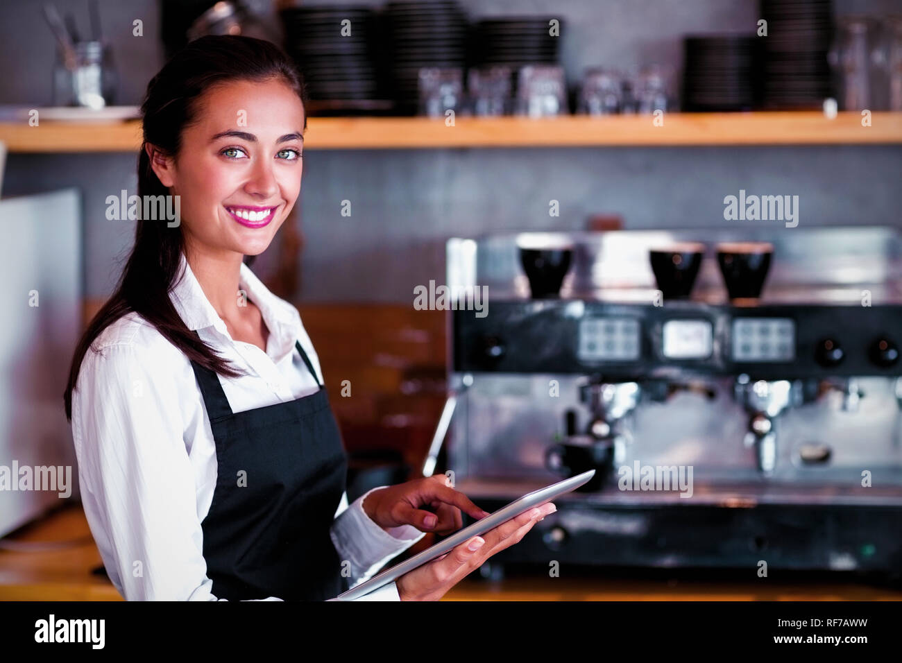 Portrait of smiling waitress using digital tablet Stock Photo