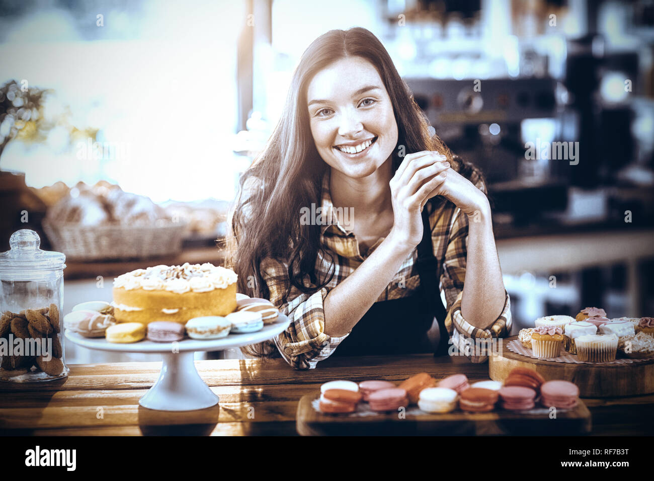 Portrait of waitress standing at counter with desserts Stock Photo